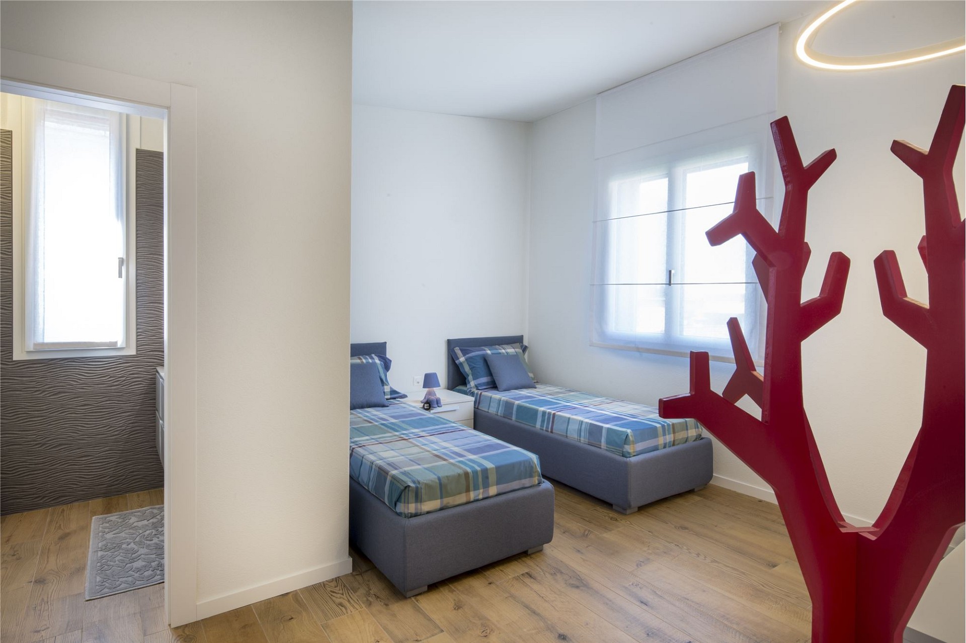 Hell eingerichtetes Kinderzimmer mit zwei Einzelbetten