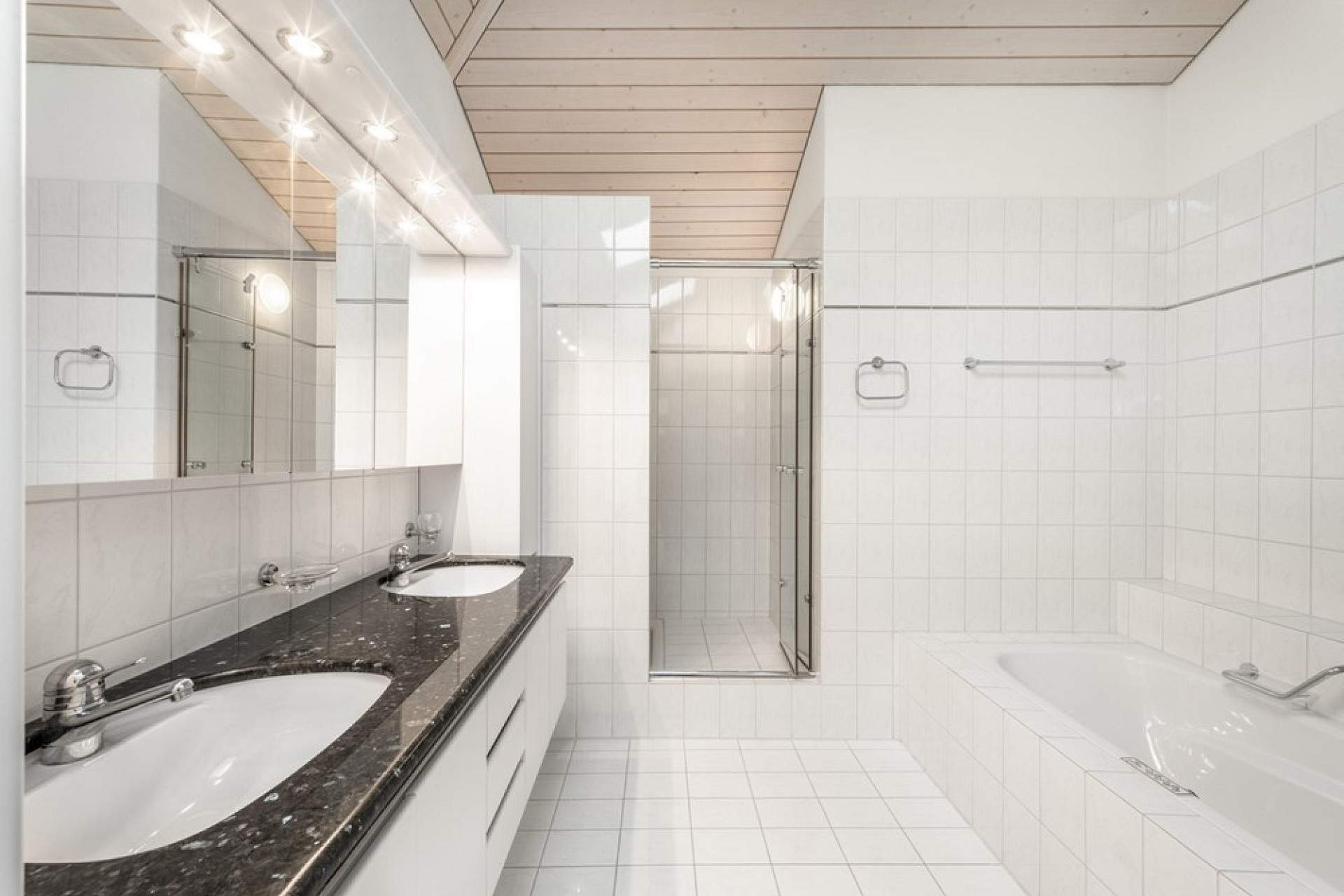 Helles Badezimmer mit Doppelwaschtisch und Badewanne