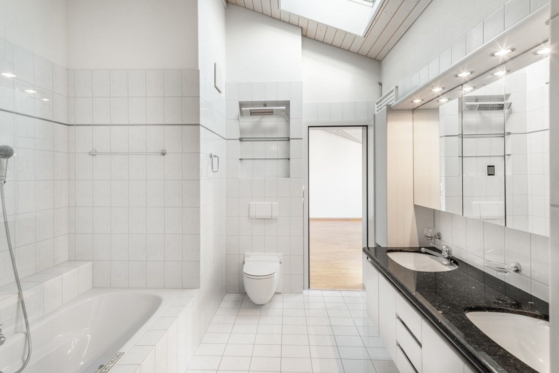 Helles Badezimmer mit Badewanne, WC und Doppelwaschtisch