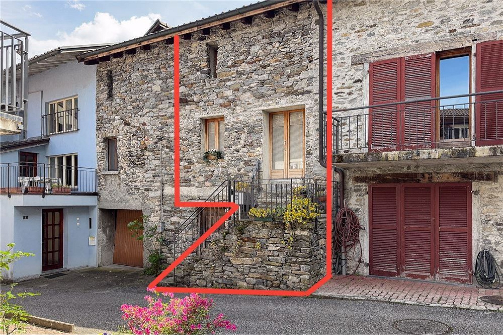 Historische Steinfassade mit roten Fensterläden