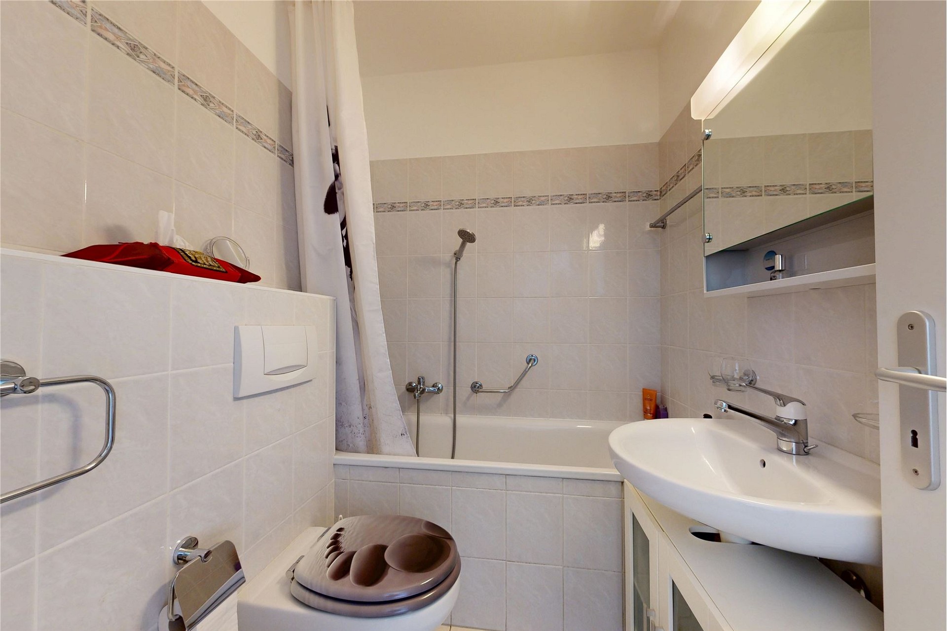 Kleines Badezimmer mit Badewanne und Waschtisch