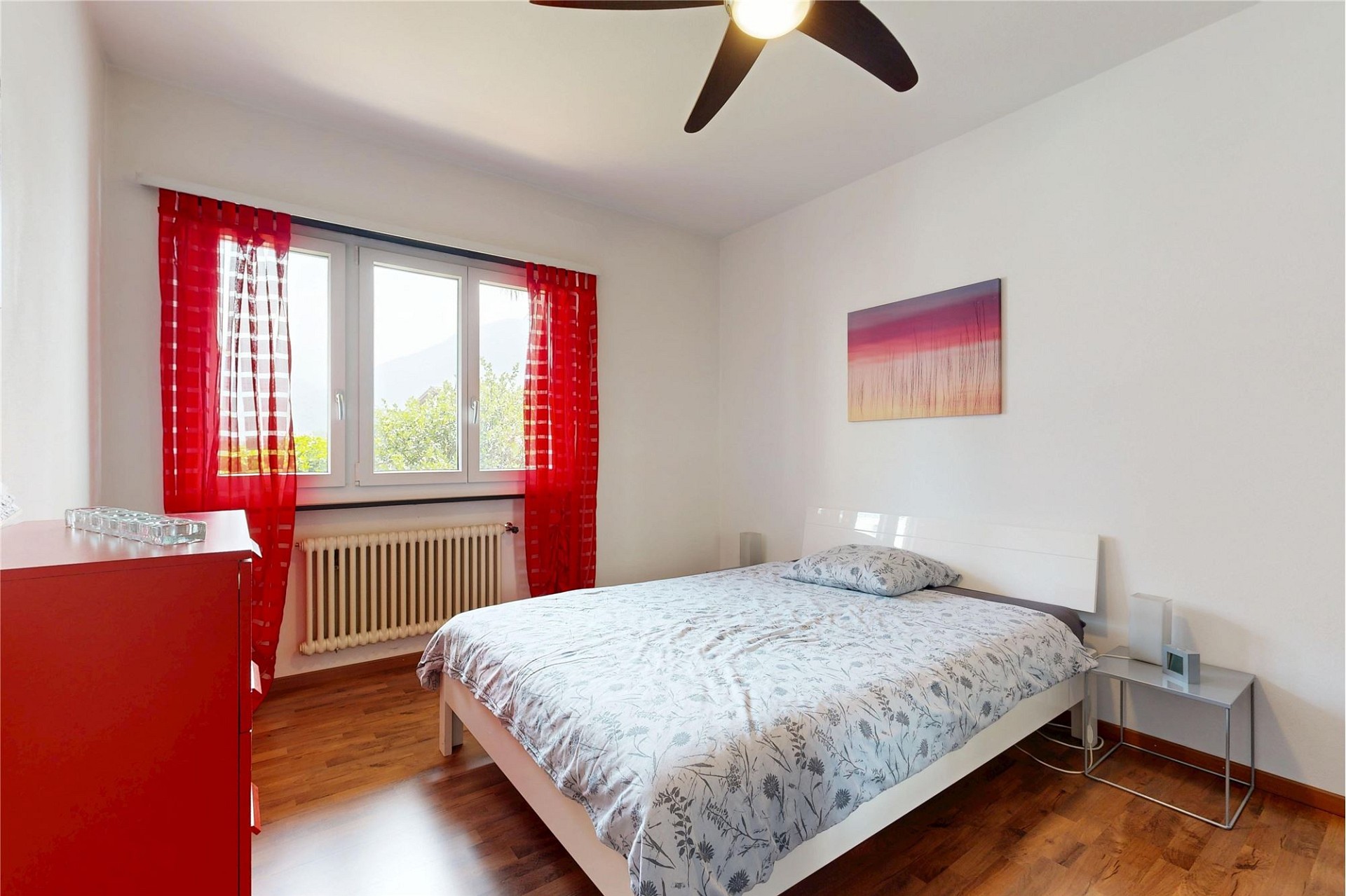 Helles Schlafzimmer mit roter Vorhangakzentfarbe