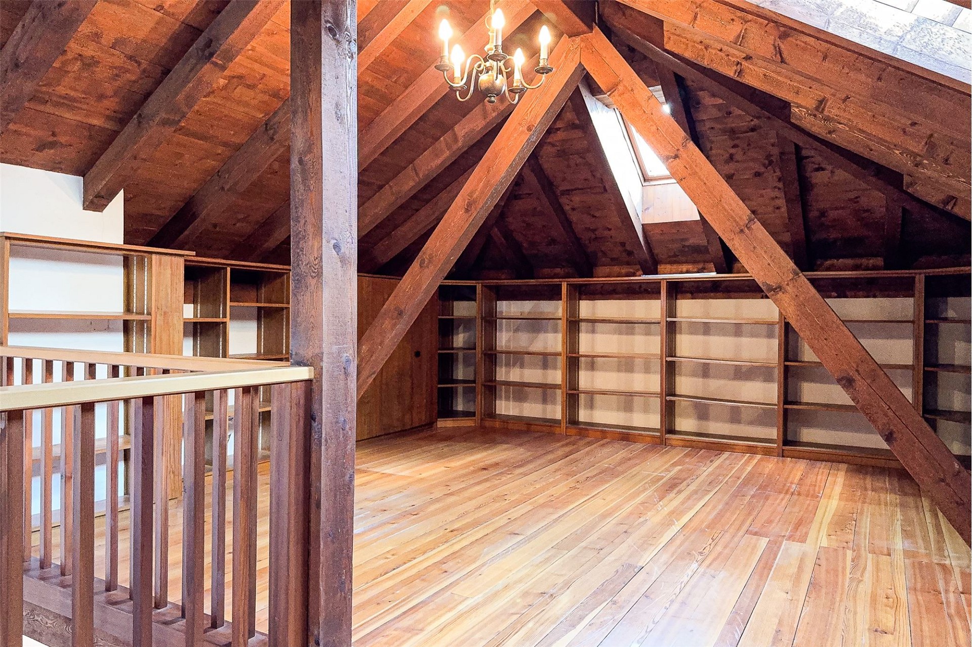 Dachgeschoss mit Holzbalken und Einbauregalen