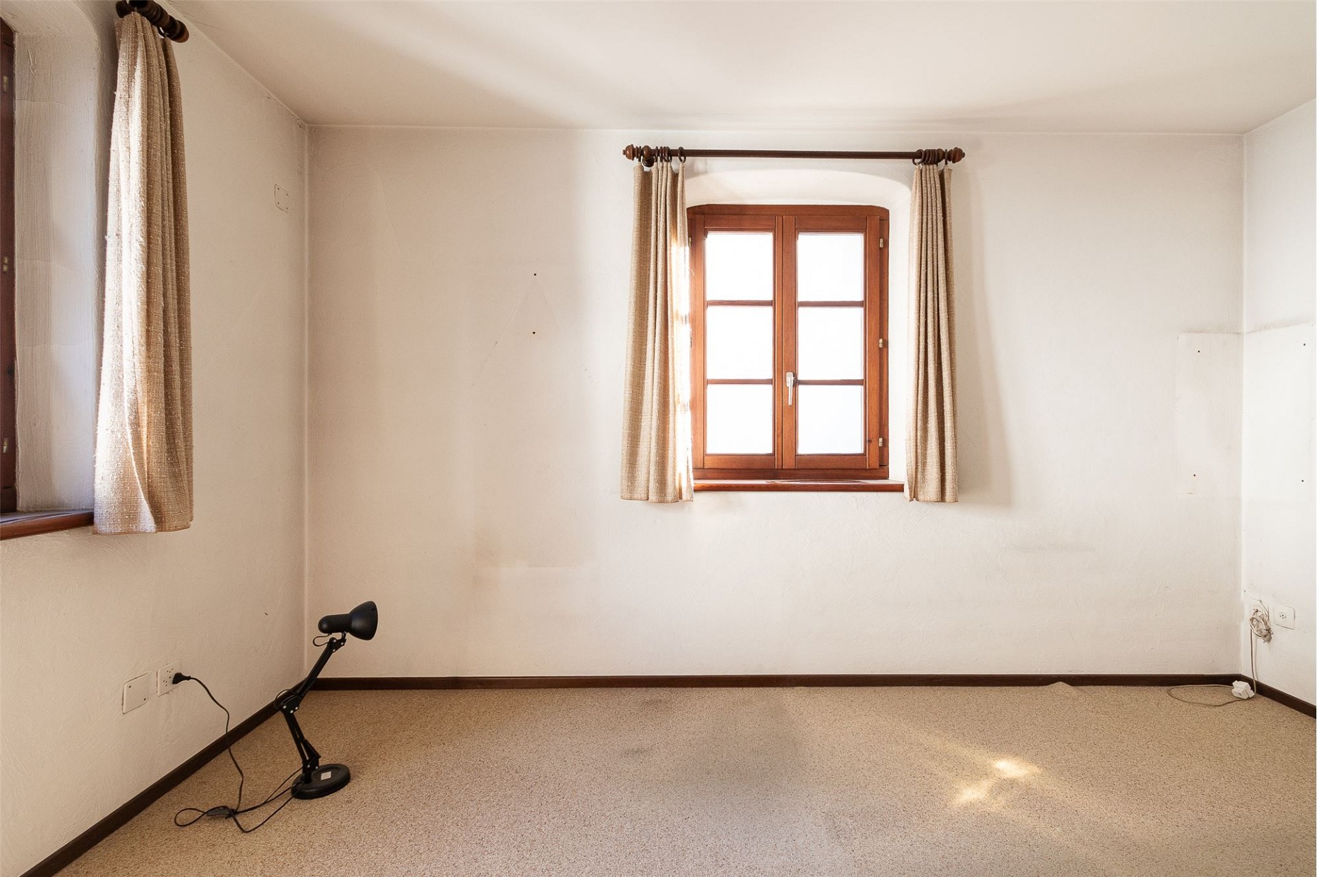 Leerer Raum mit Fenstern und Teppichboden