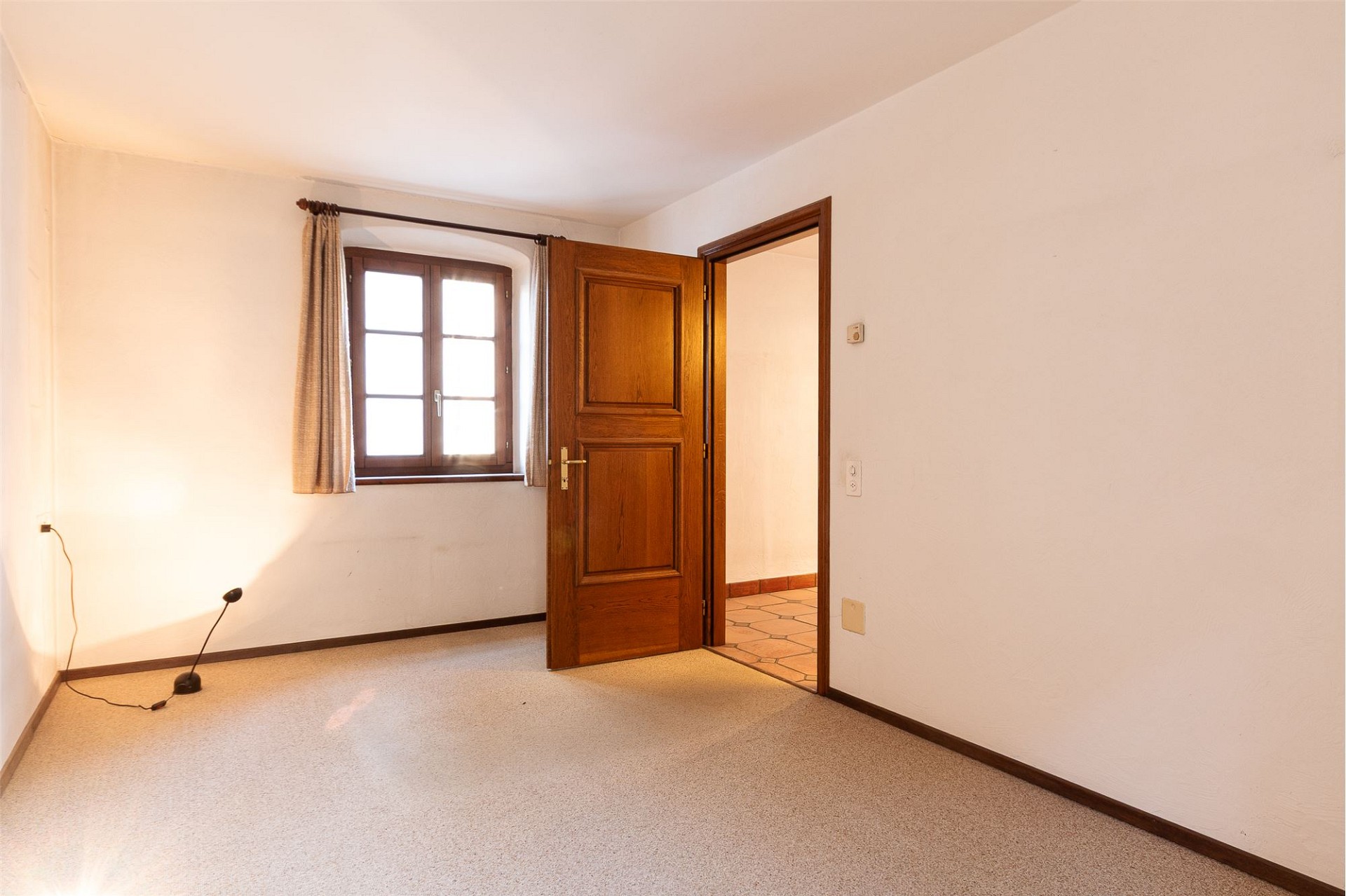 Leeres Zimmer mit Holzfenster und offener Tür