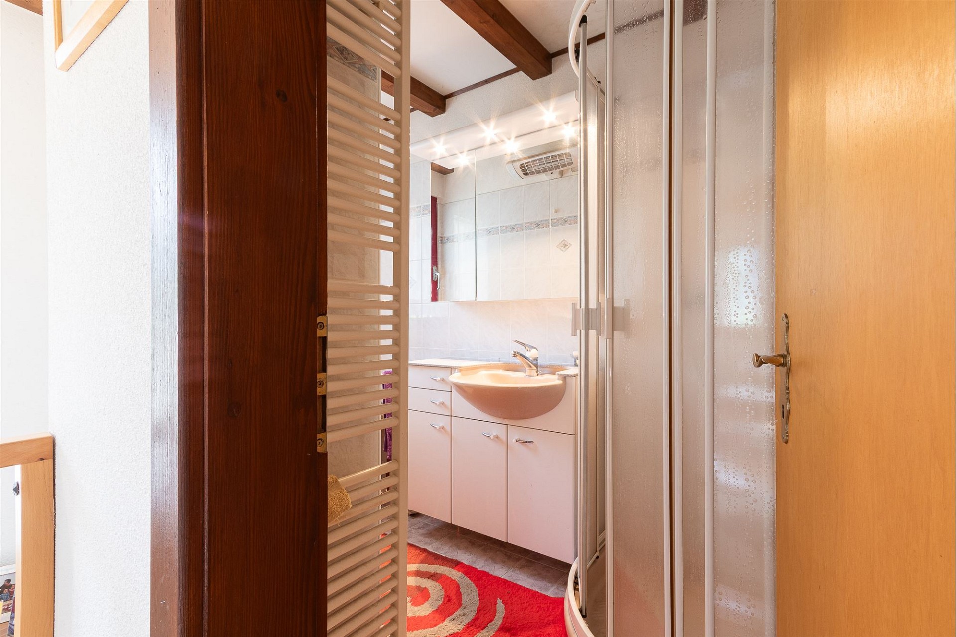 Kleines Badezimmer mit Dusche und Waschtisch