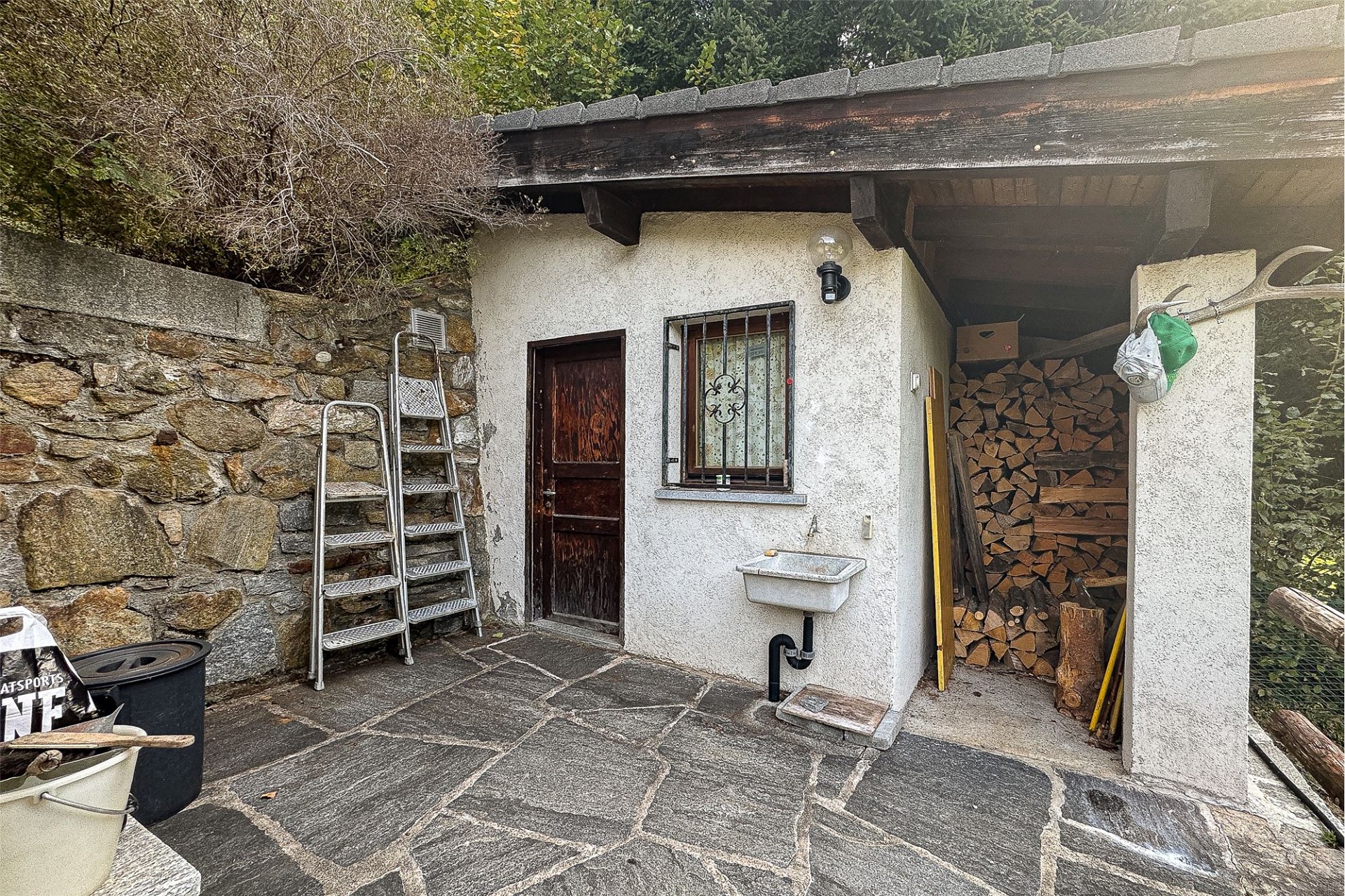Außenbereich mit kleiner Hütte und Holzlager