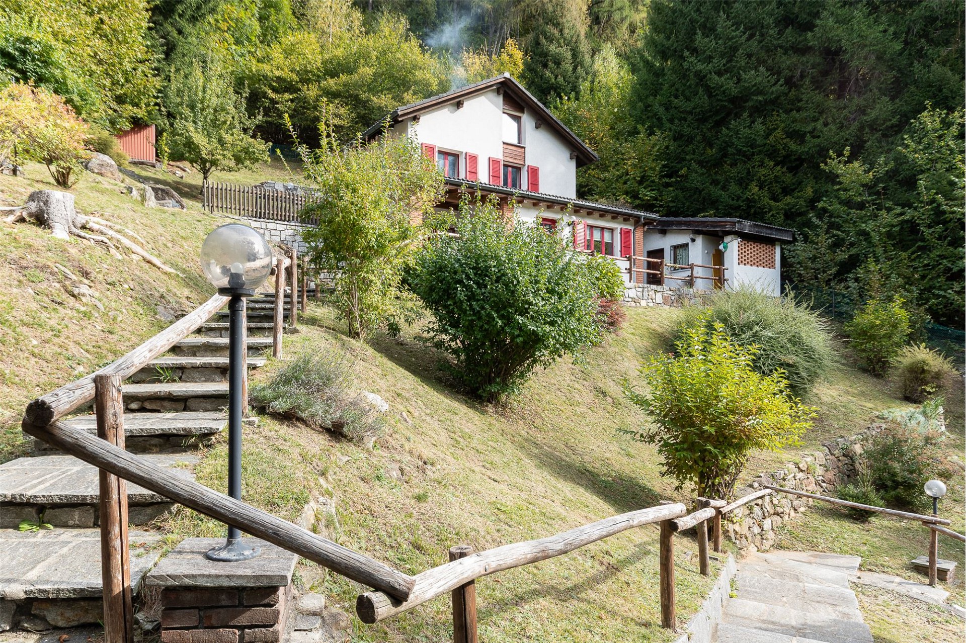 Ländliches Haus am Hang mit Garten und Außentreppe