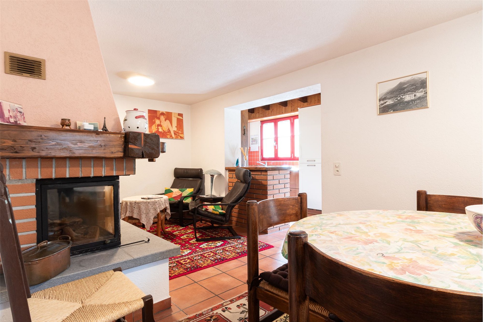 Wohn-Essbereich mit Kamin und Durchgang zur Küche