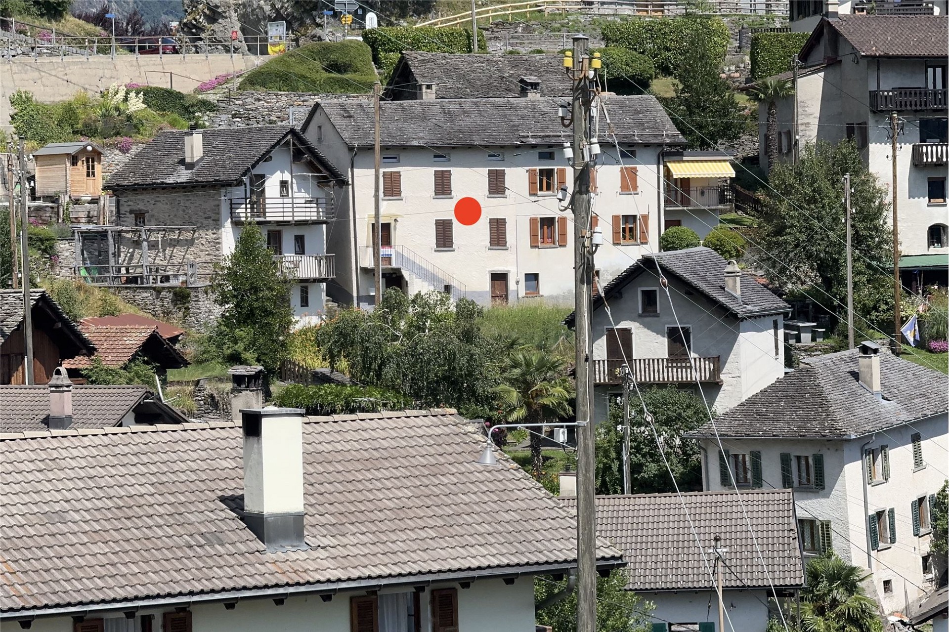 Dorfansicht mit mehreren Häusern und Hanglage