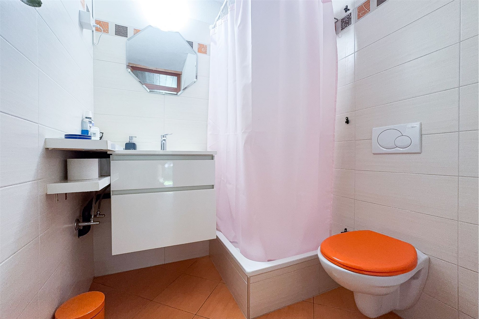 Kompaktes Badezimmer mit pinkem Duschvorhang