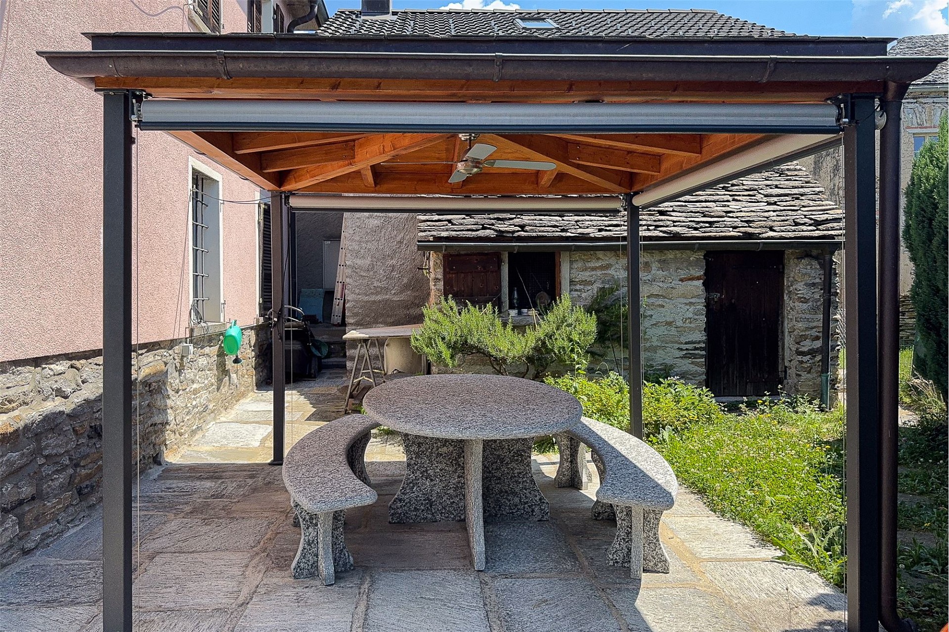 Überdachte Terrasse mit Steinmöbeln