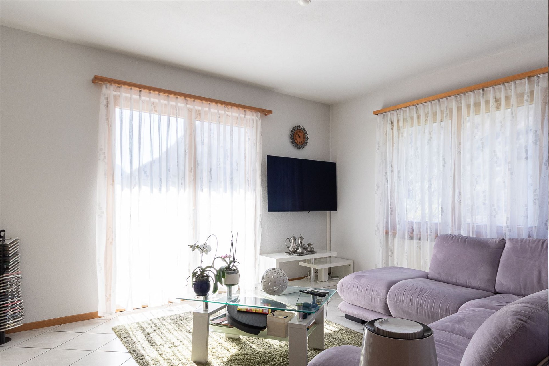 Helles Wohnzimmer mit Ecksofa und TV