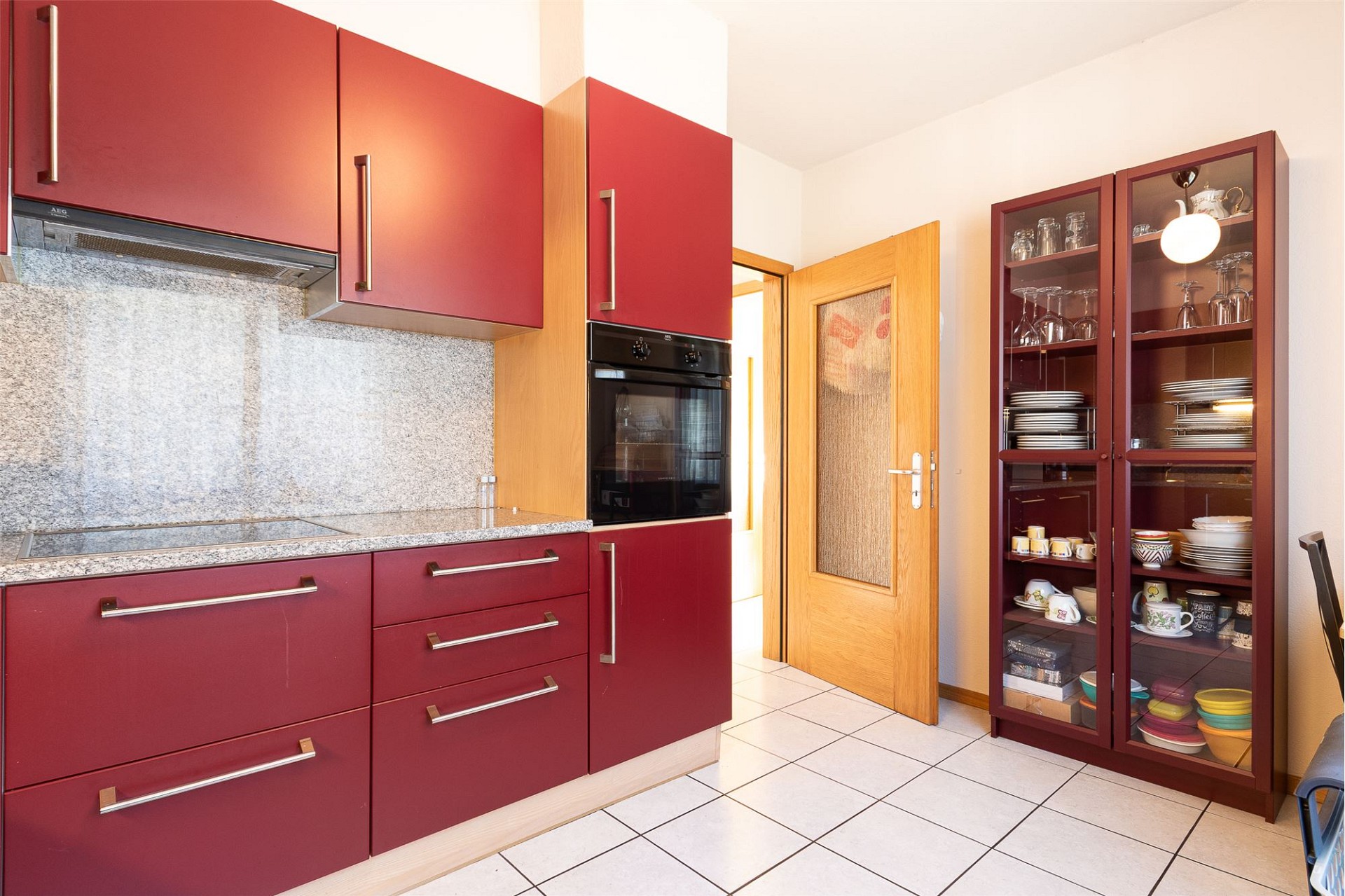 Bunte Einbauküche mit Vitrinenschrank