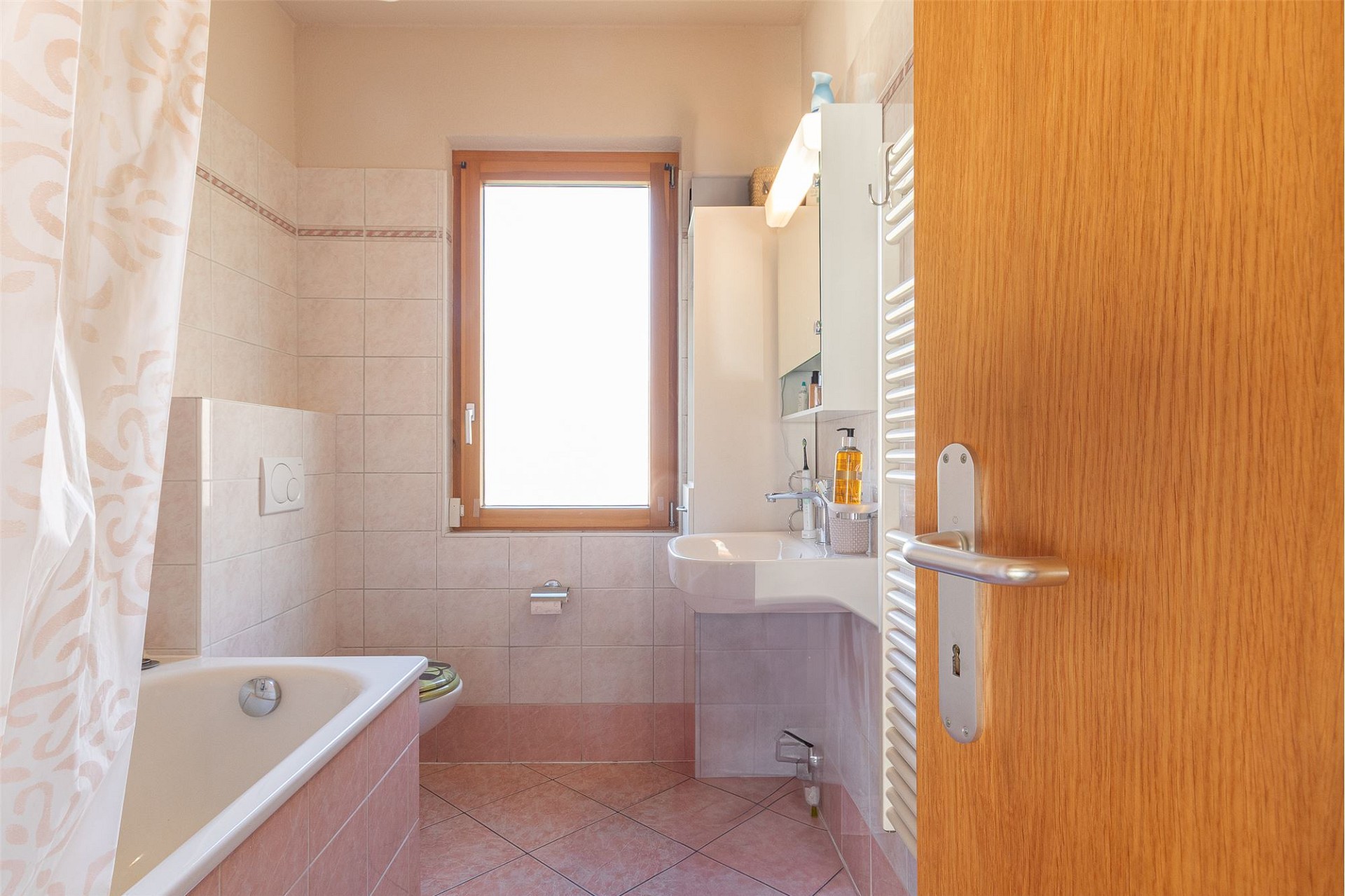 Kleines Badezimmer mit Badewanne und Fenster