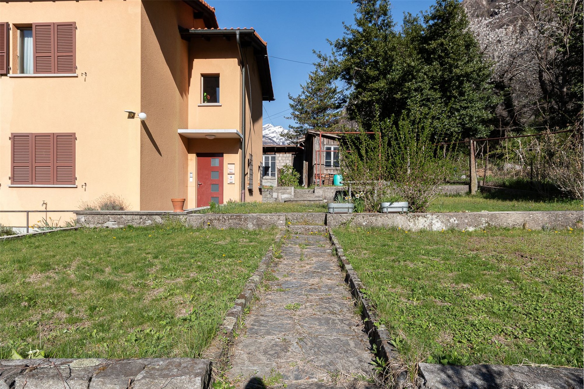 Haus mit Garten und Bergkulisse