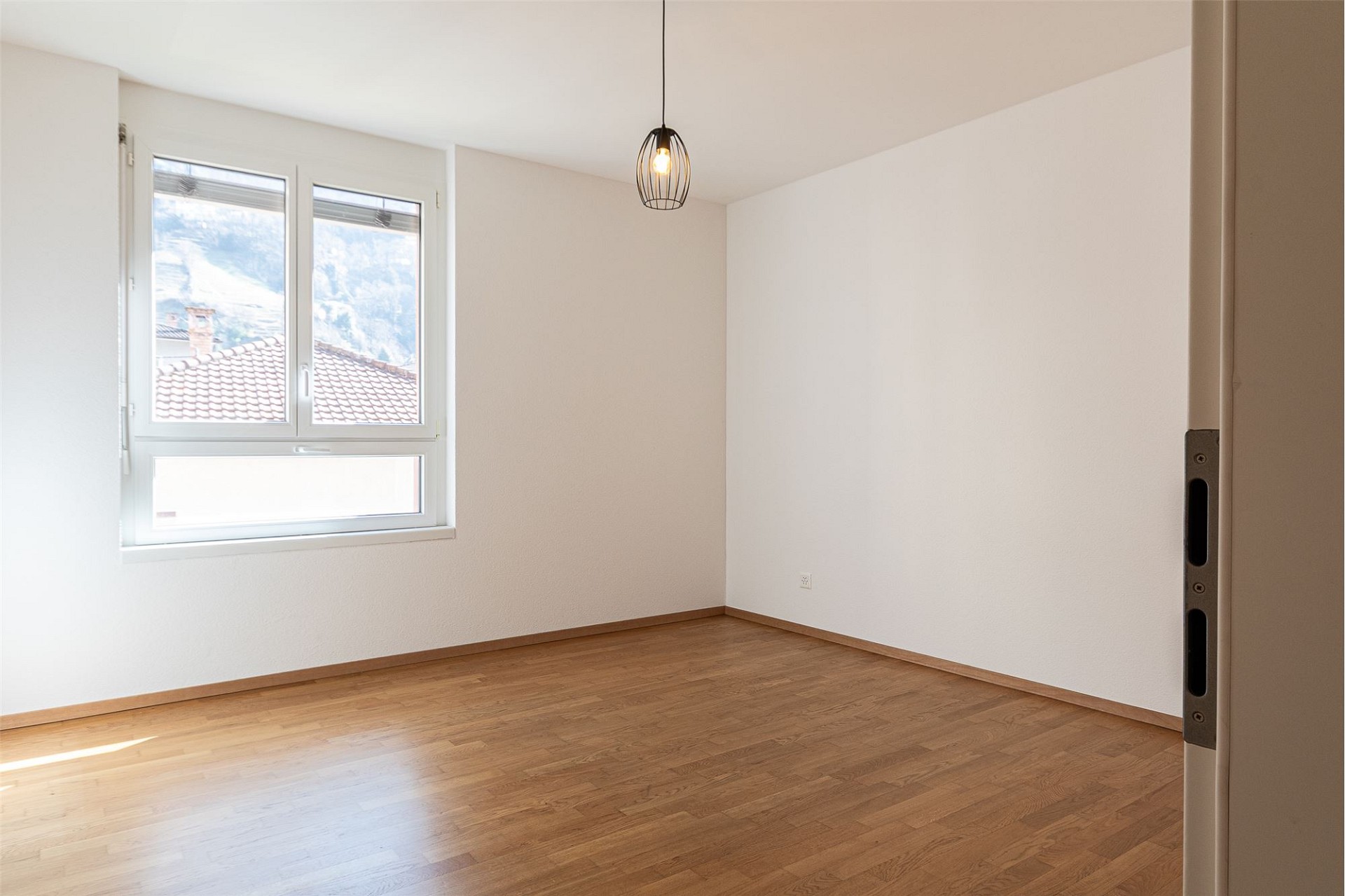 Leeres, helles Zimmer mit Parkettboden