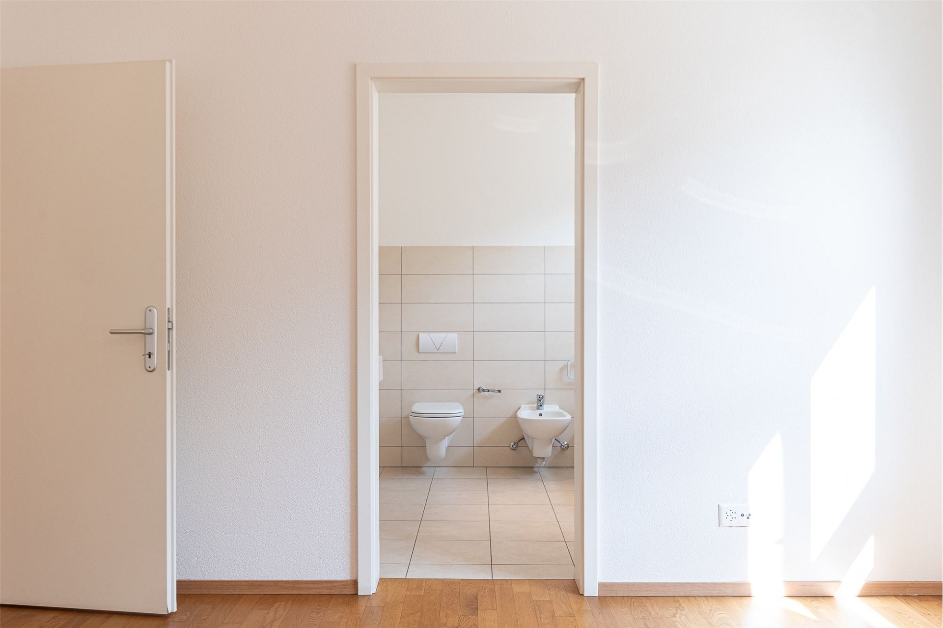 Helles, schlichtes Innenbild mit Blick in ein Bad/WC