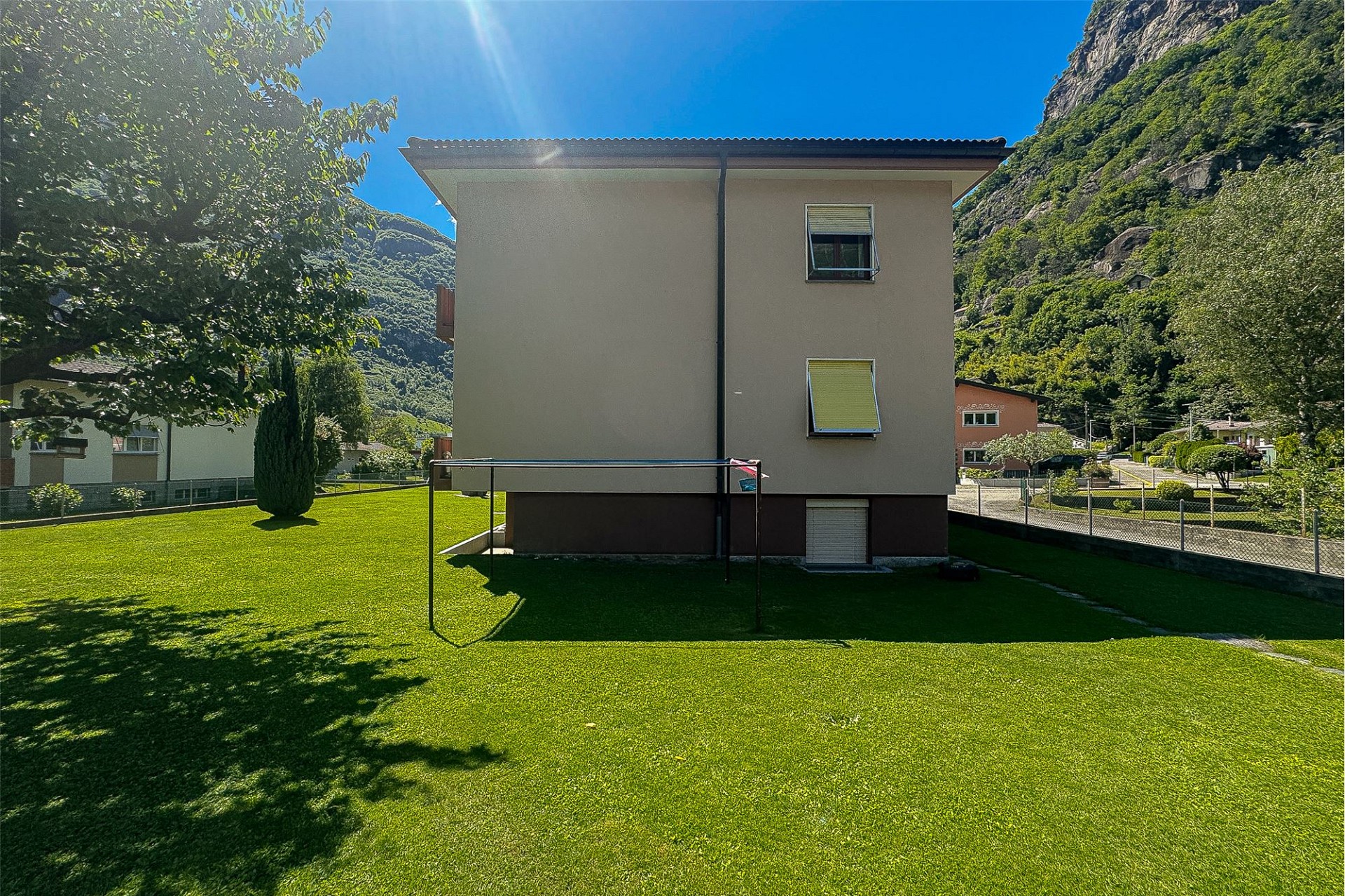 Außenansicht eines Hauses mit großem Garten und Bergkulisse