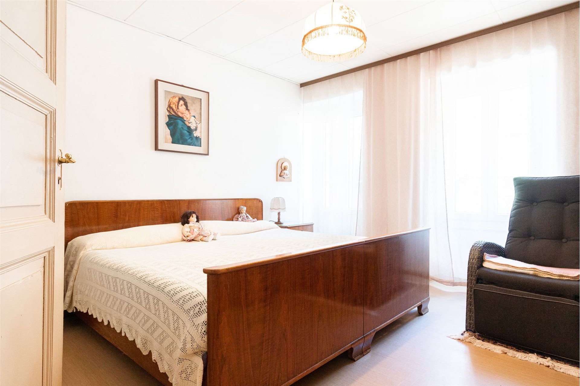 Helles Schlafzimmer mit klassischem Holzbett und Vintage-Möbeln