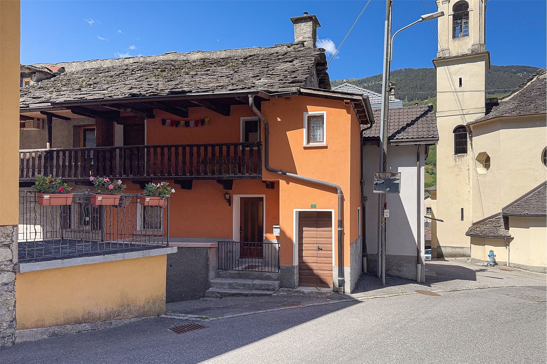Traditionelles Dorfhaus mit Balkon und Steildach