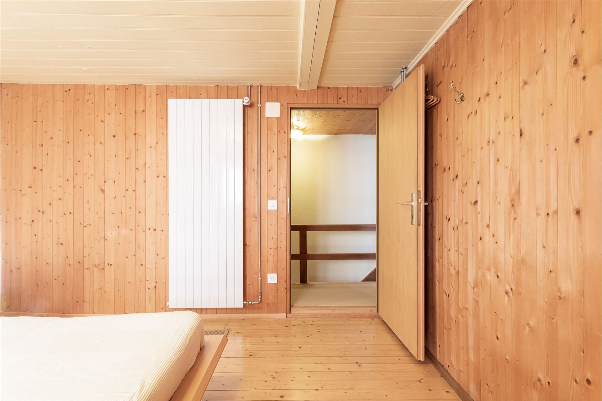 Holzvertäuschtes Schlafzimmer mit offenem Türbereich