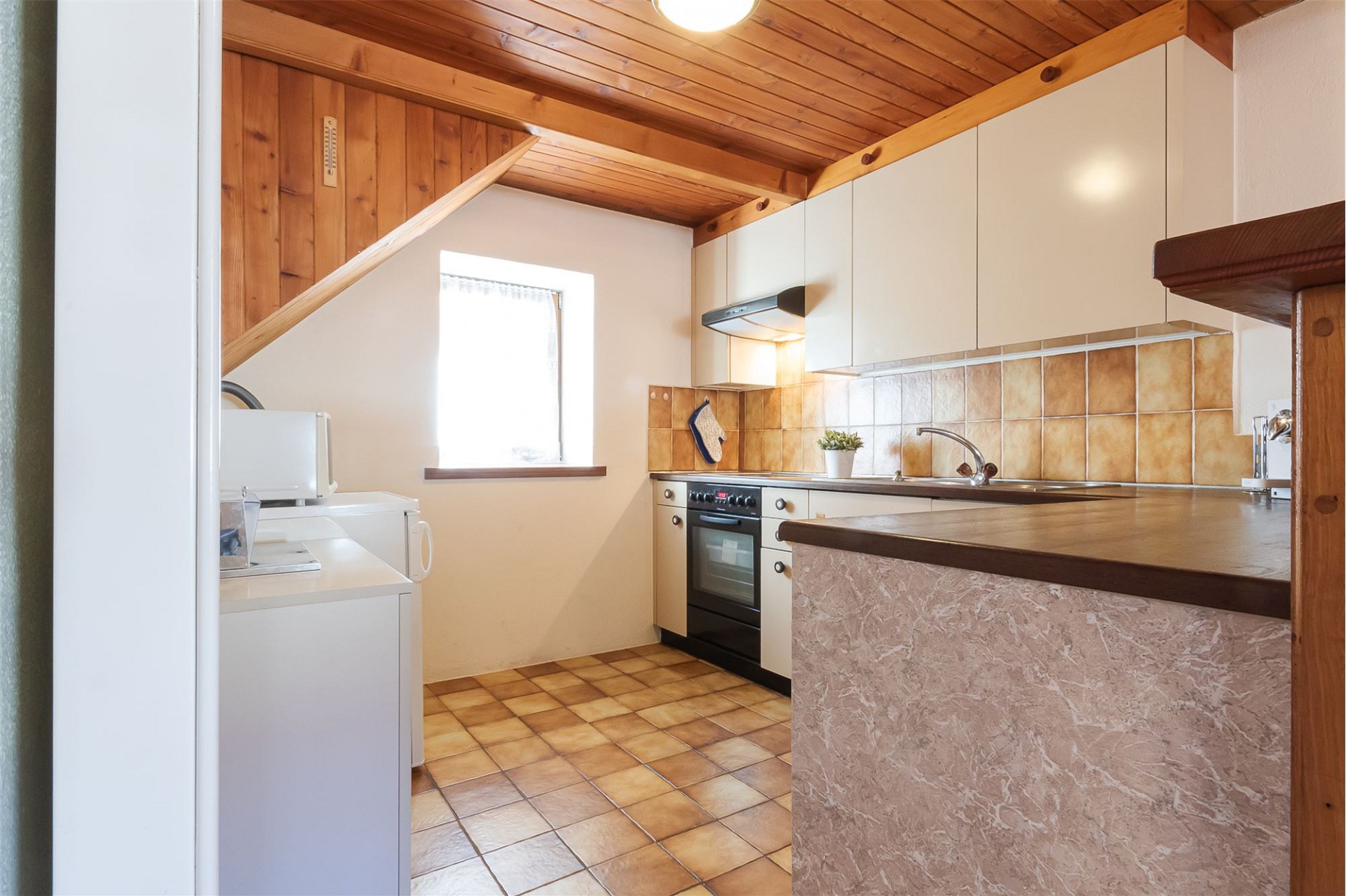 Kleine rustikale Küche mit Holzdecke