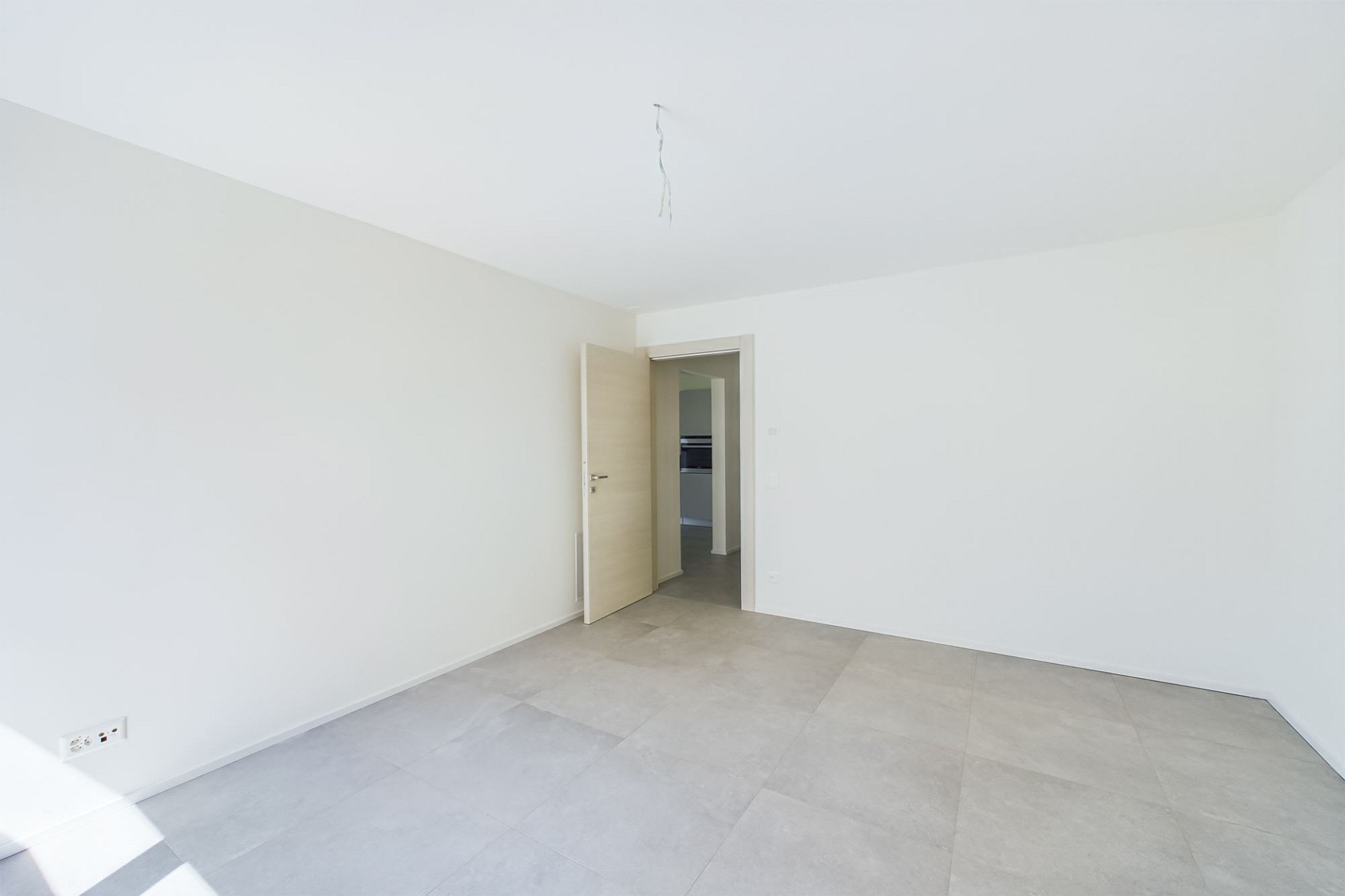 Leeres, helles Zimmer mit Fliesenboden