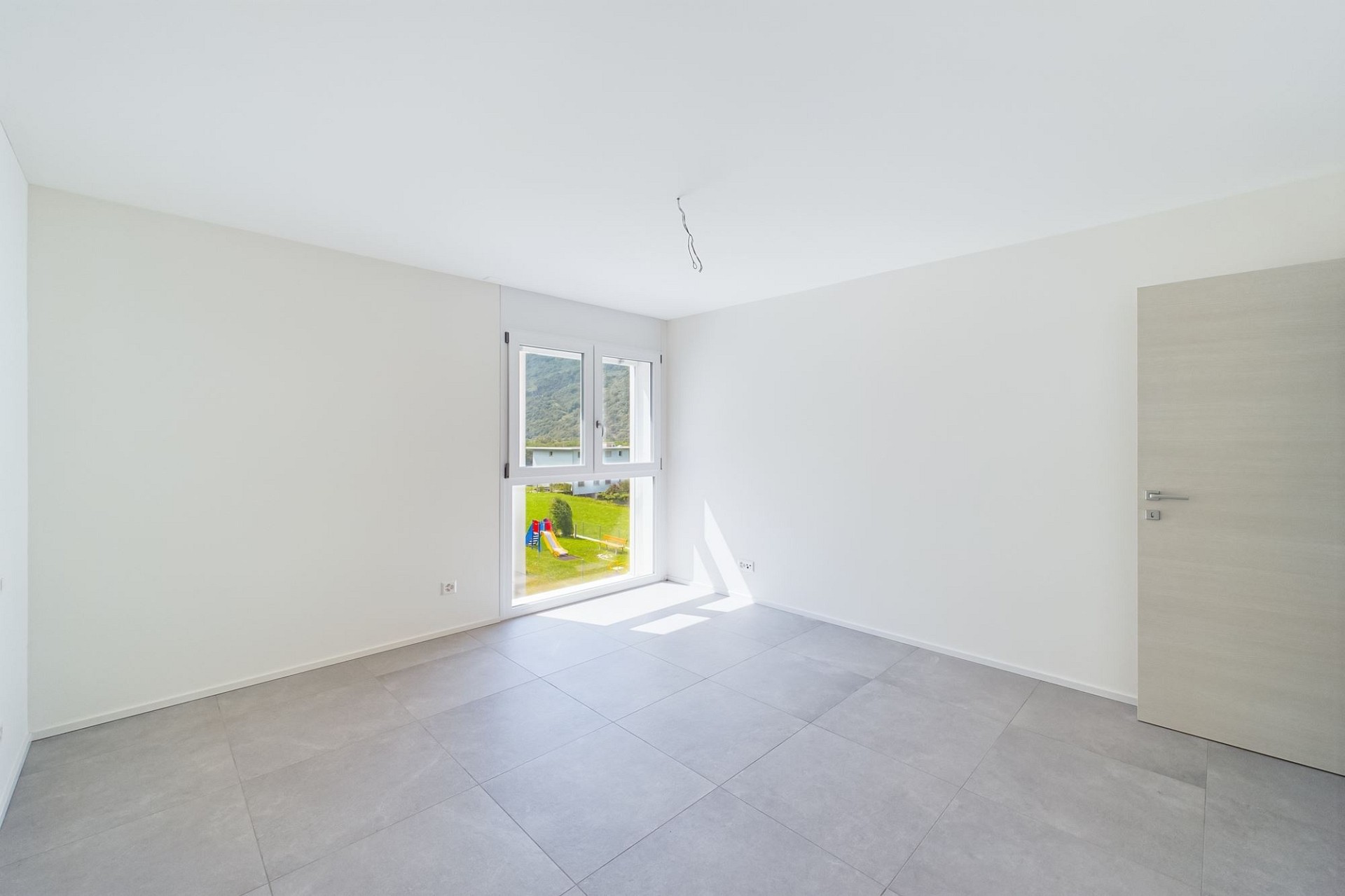 Helles, leeres Zimmer mit großem Fenster