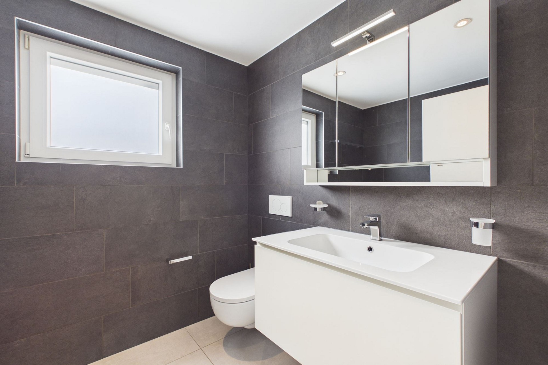 Modernes Badezimmer mit dunkler Wandverkleidung und weißem Waschtisch