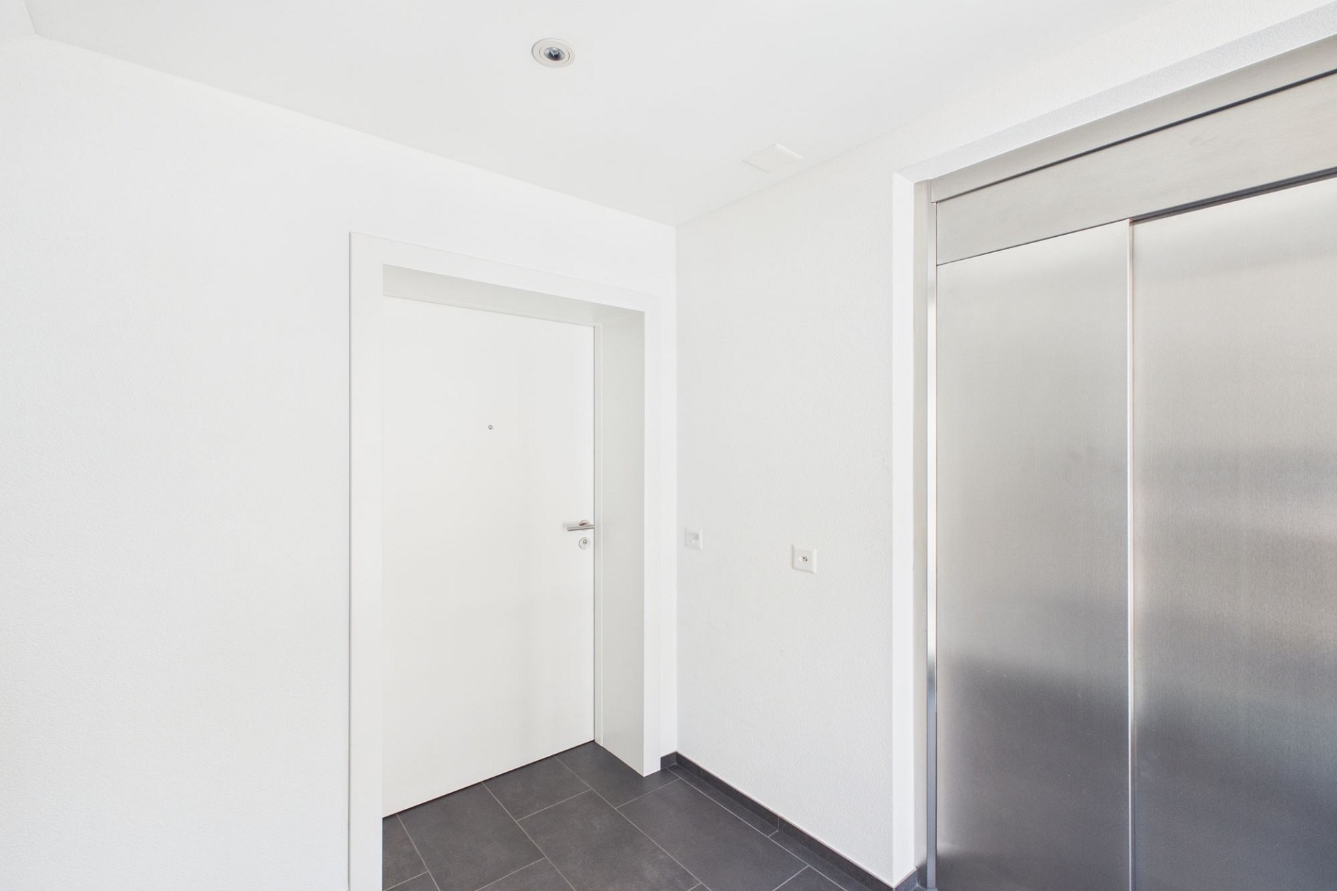 Heller Eingangsbereich mit Tür und Einbauschrank