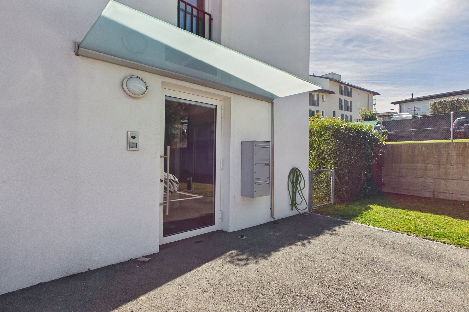 Moderner Hauszugang mit Eingangstür, Vordach und Gartenbereich