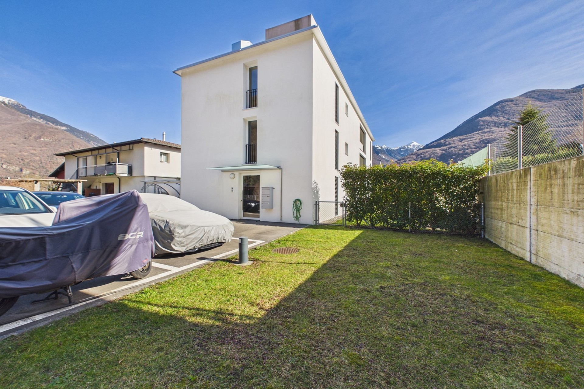 Modernes Wohnhaus mit Garten und Bergkulisse