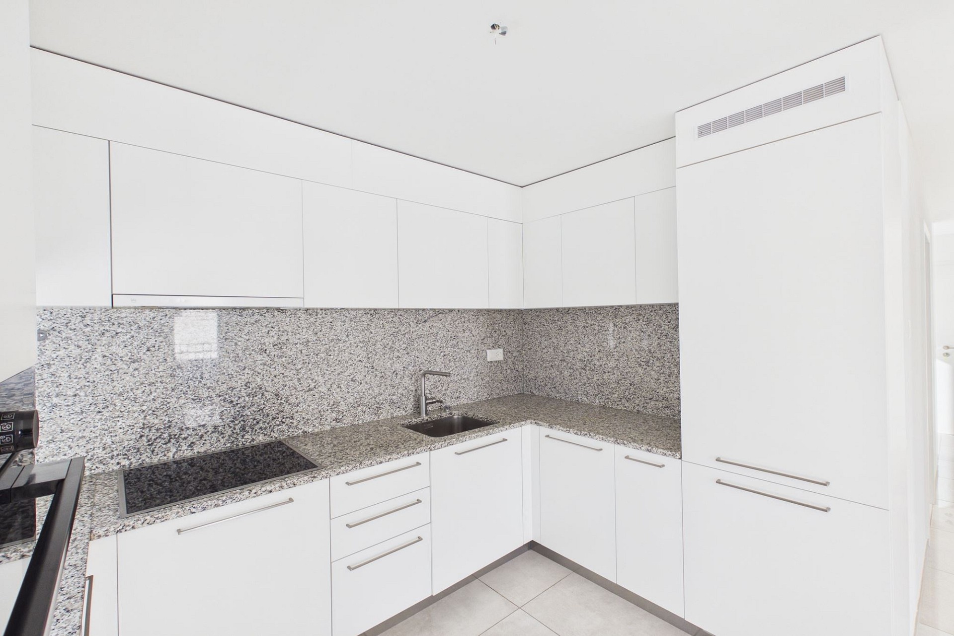 Moderne weiße Küche mit Granitoberflächen