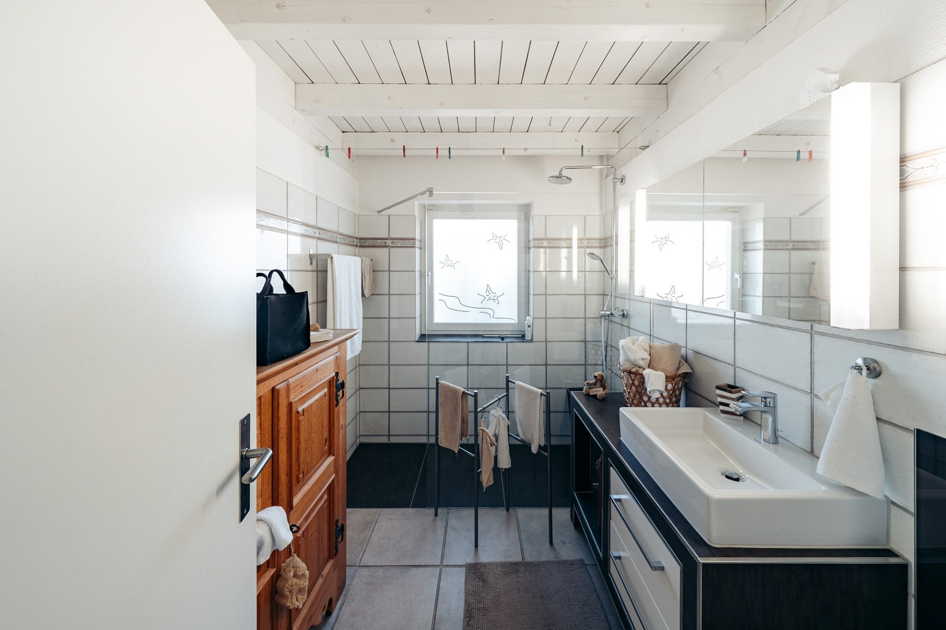 Helles Badezimmer mit Fenster und Holzakzent