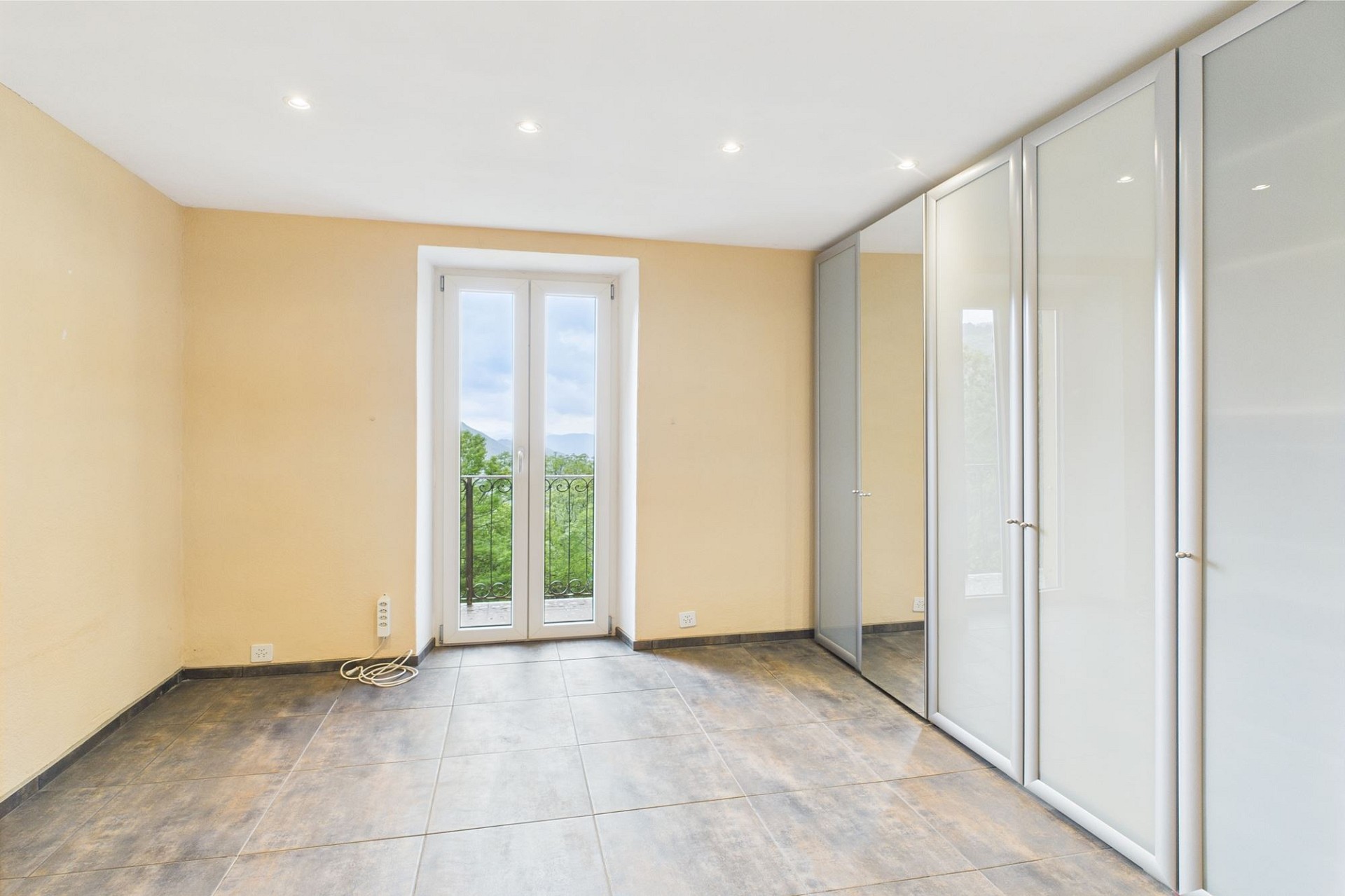 Helles, leer stehendes Zimmer mit Balkonblick
