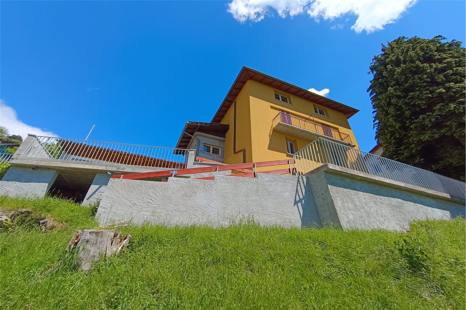 Gelbes Wohnhaus mit Balkon und Hanglage