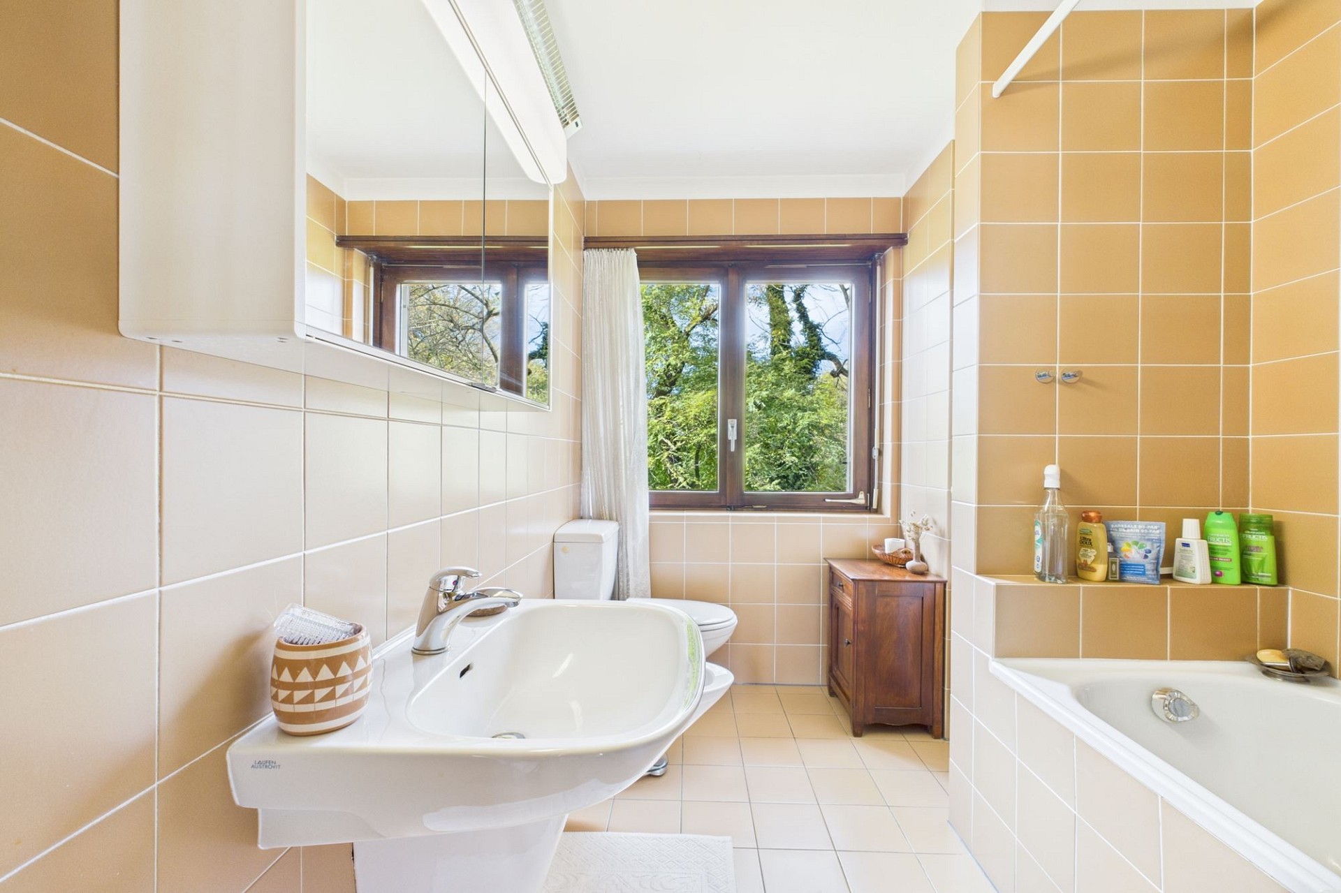Helles Badezimmer mit Badewanne und Blick ins Grüne