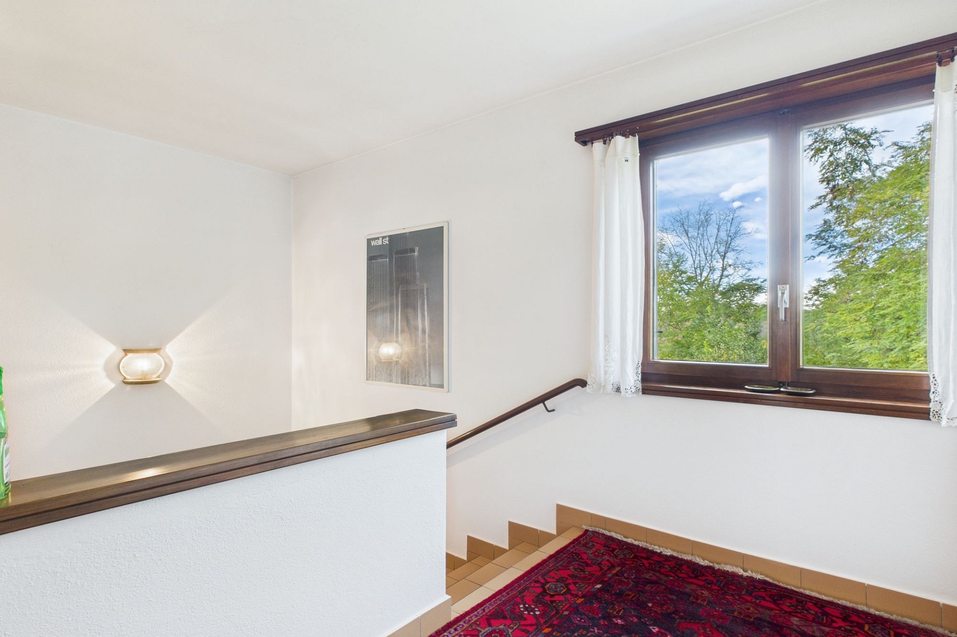 Treppenhaus mit Fenster und Wandlampe