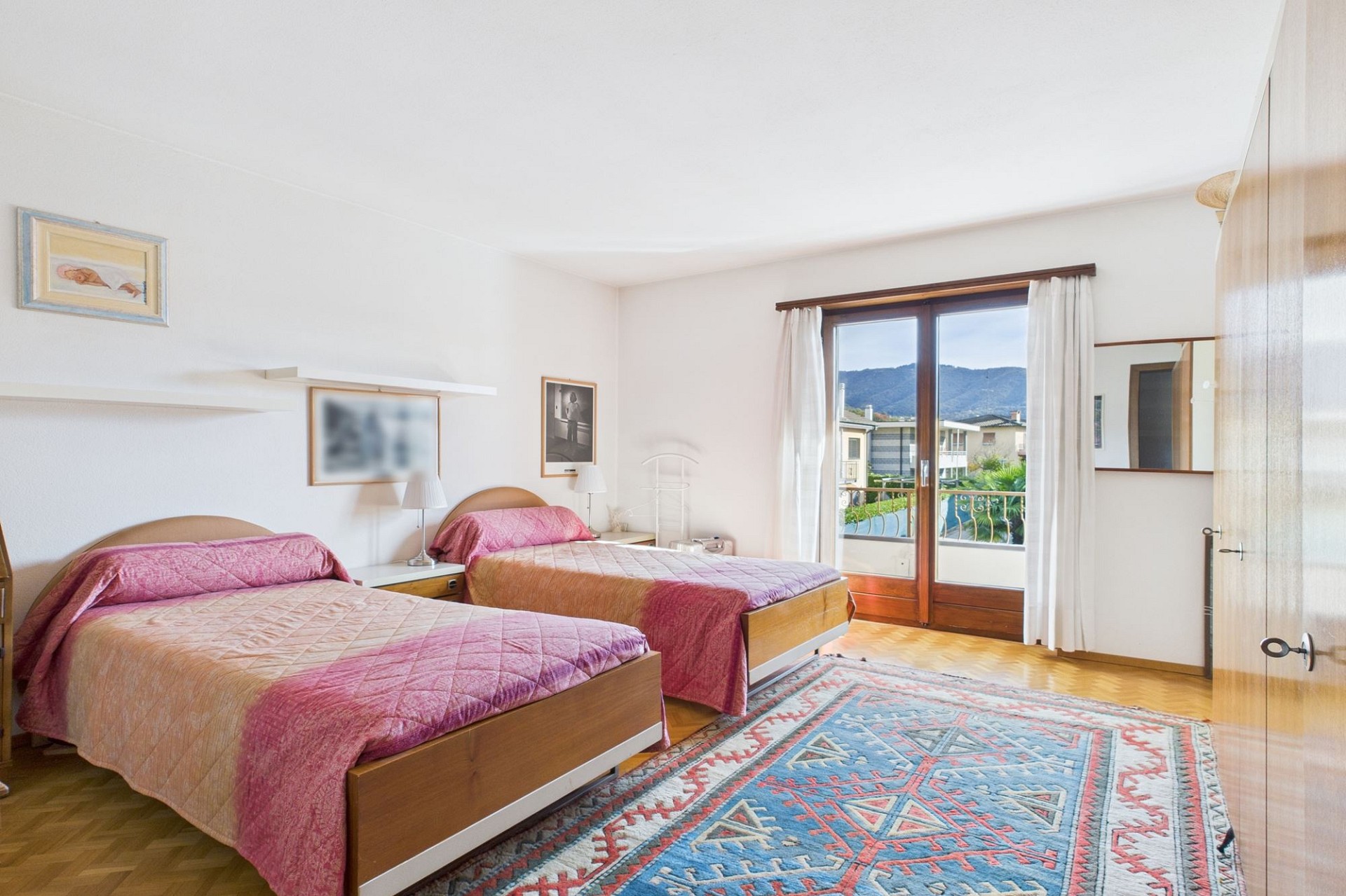 Schlafzimmer mit zwei Einzelbetten und Balkonblick