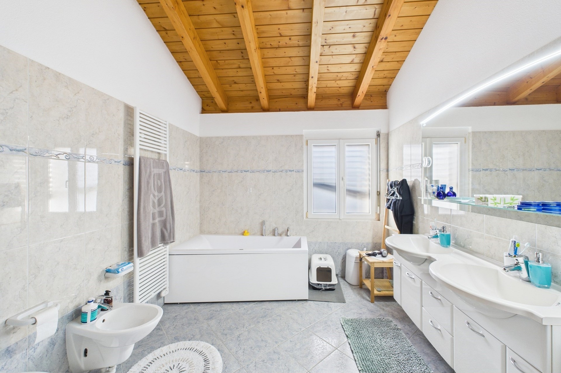Helles Badezimmer mit Holzdecke und Doppelwaschtisch