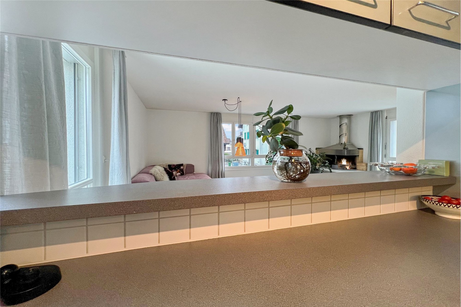 Helles Wohnzimmer mit Kamin und Blick in den Gartenbereich