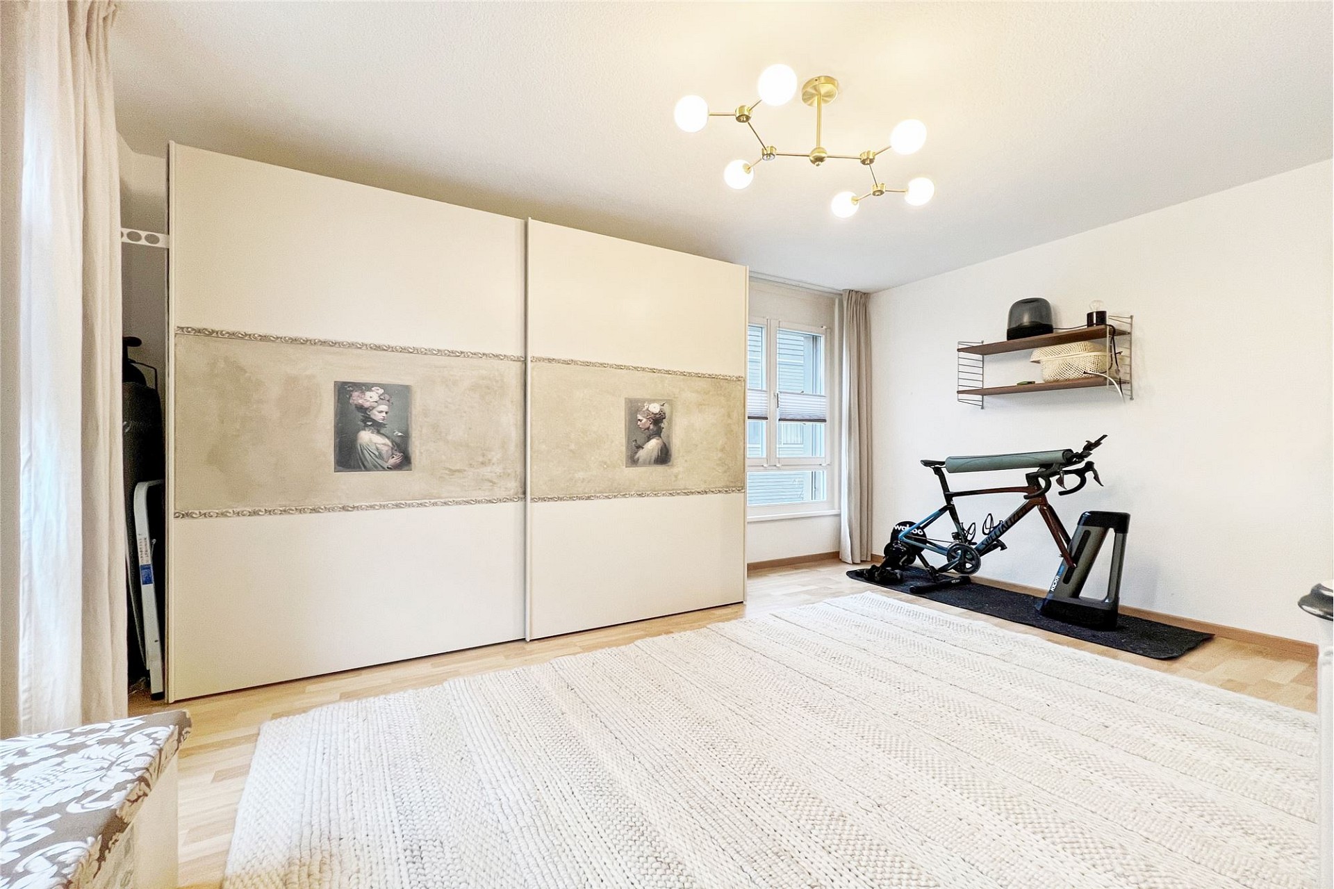 Helles Schlafzimmer mit Kleiderschrank und Trainingsrad