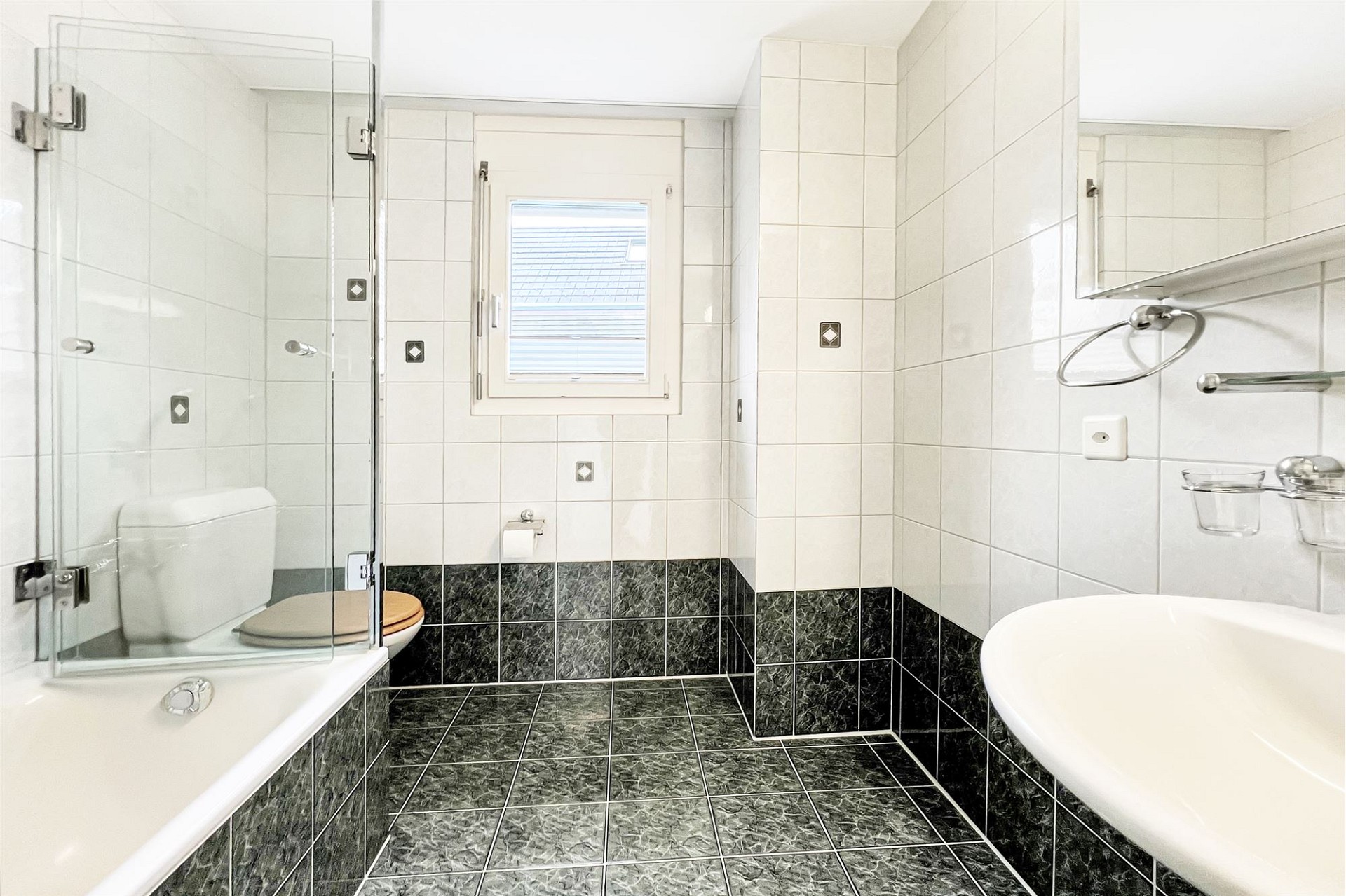 Kleines helles Badezimmer mit Badewanne und Dusche