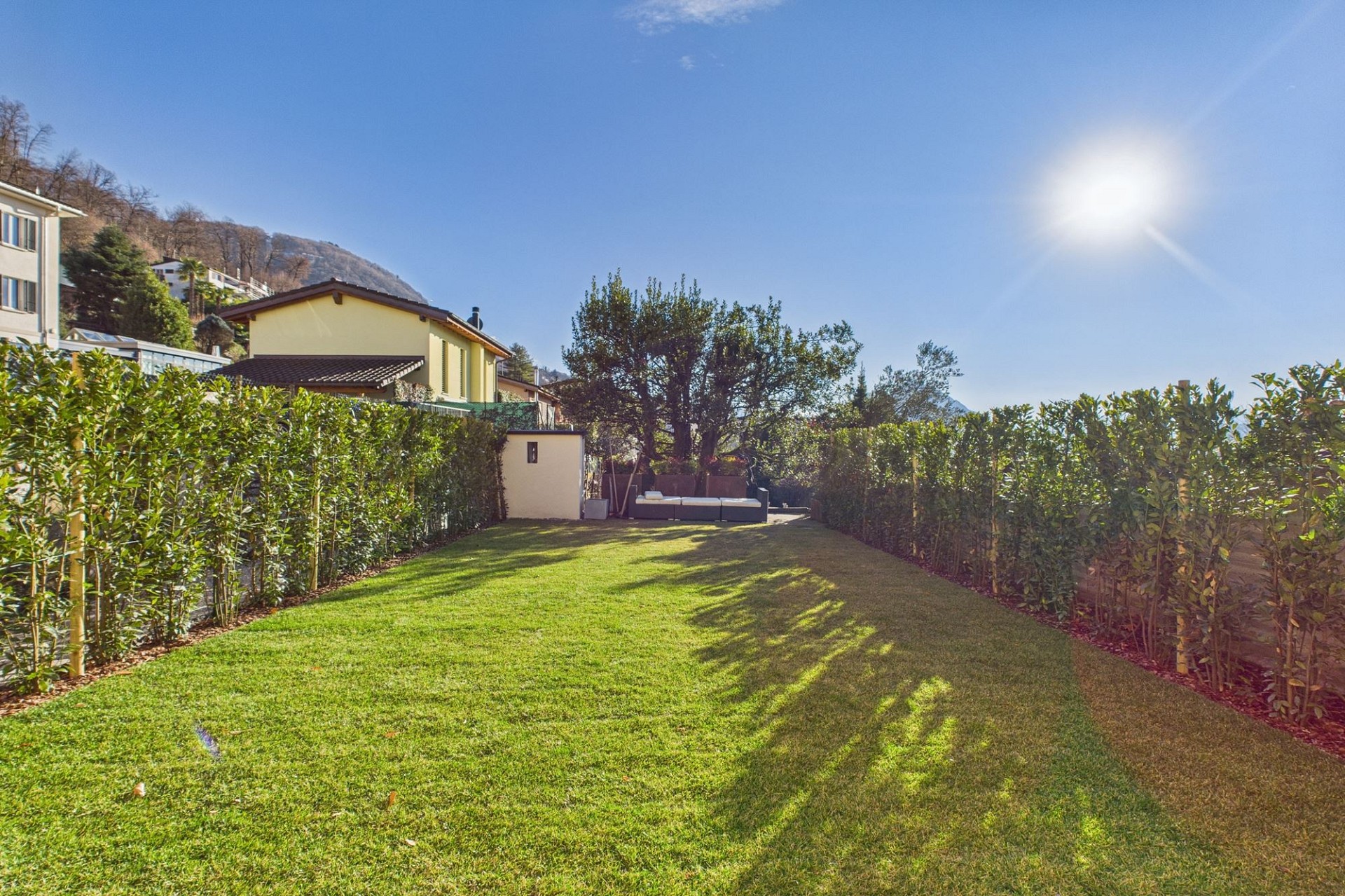 Heller Garten mit Rasen und Hecke