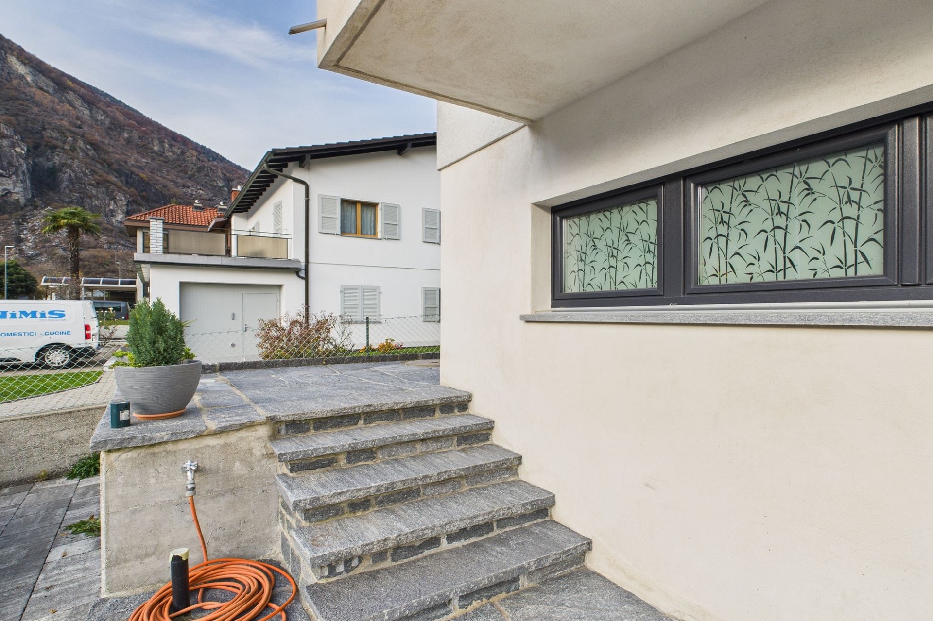 Außenansicht eines Wohnhauses mit Terrasse und Bergkulisse