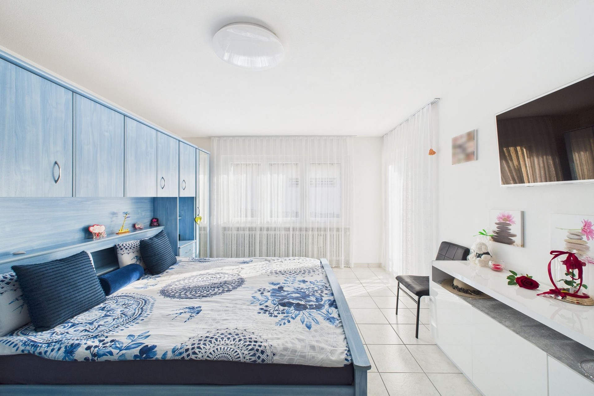 Helles Schlafzimmer mit blauer Einbauschrankwand