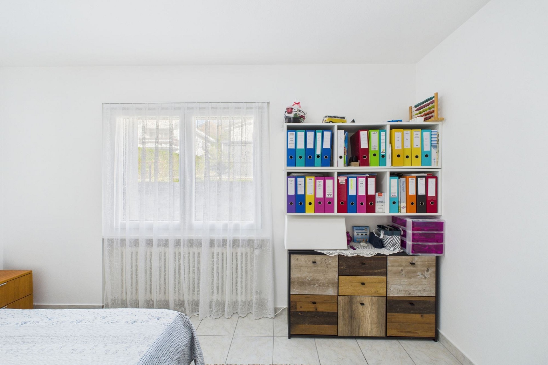 Helles Schlafzimmer mit Fenster und Regalwand
