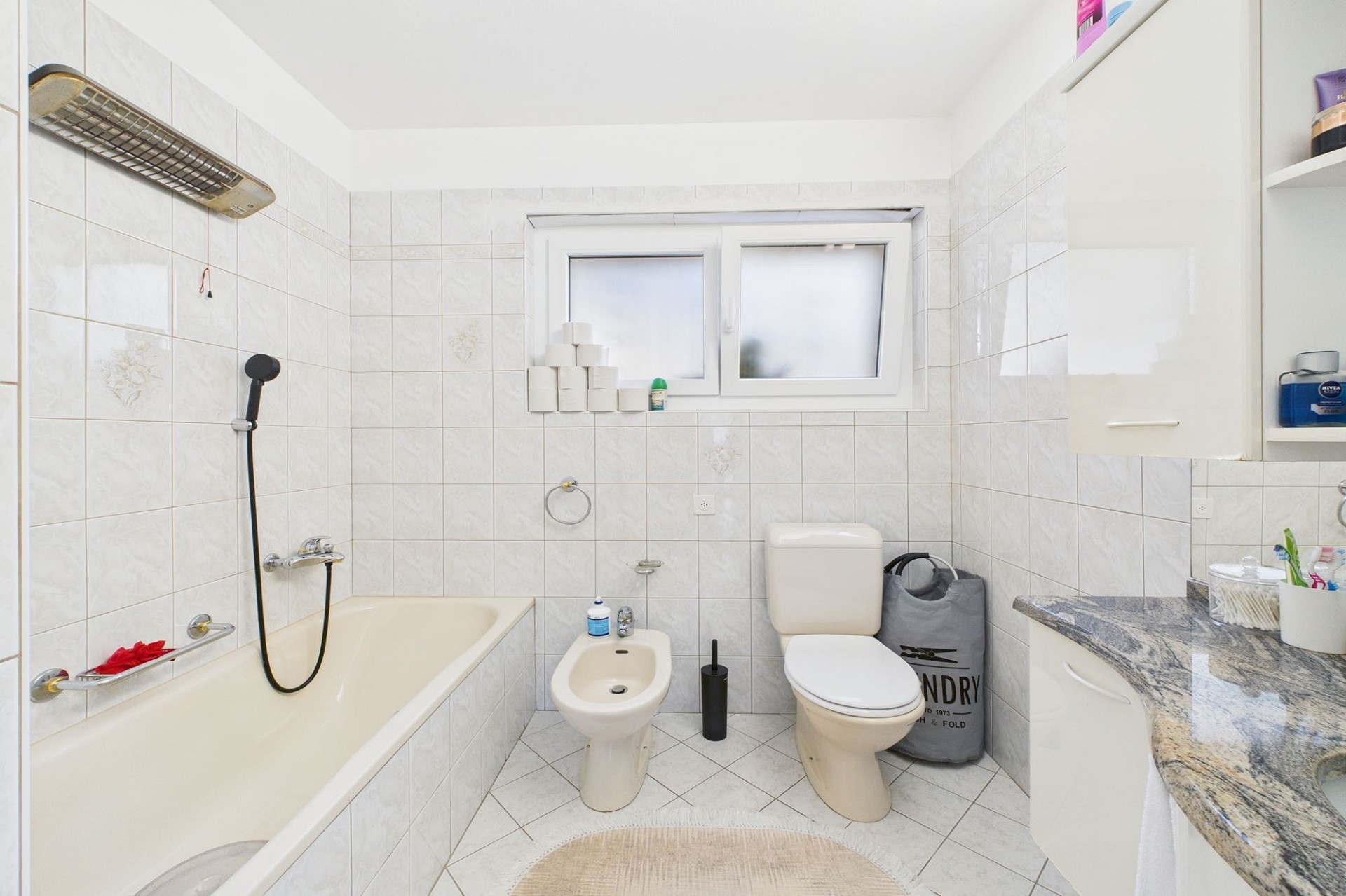 Badezimmer mit Badewanne, Toilette und Fenster
