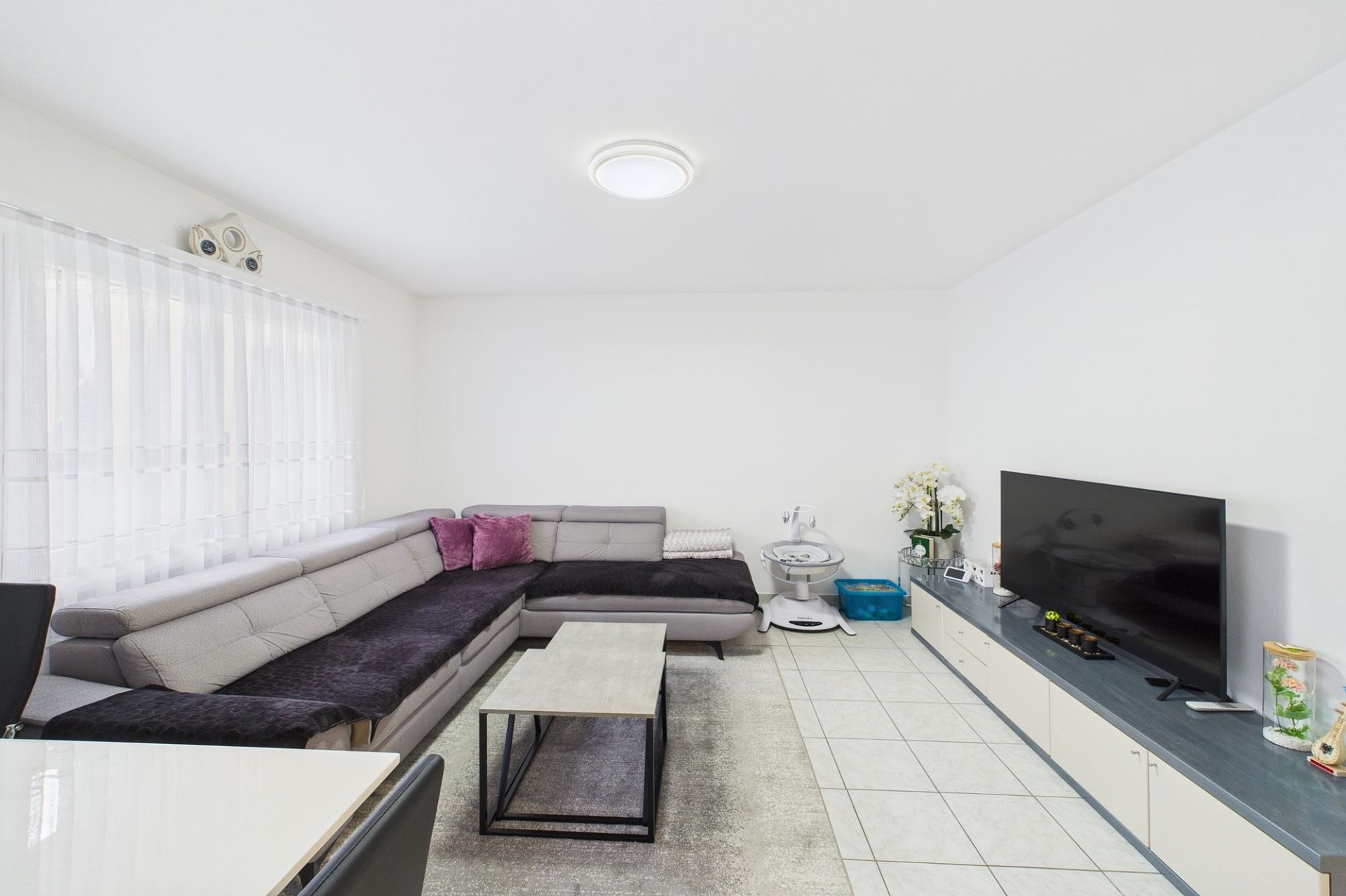 Helles Wohnzimmer mit Ecksofa und TV-Wand